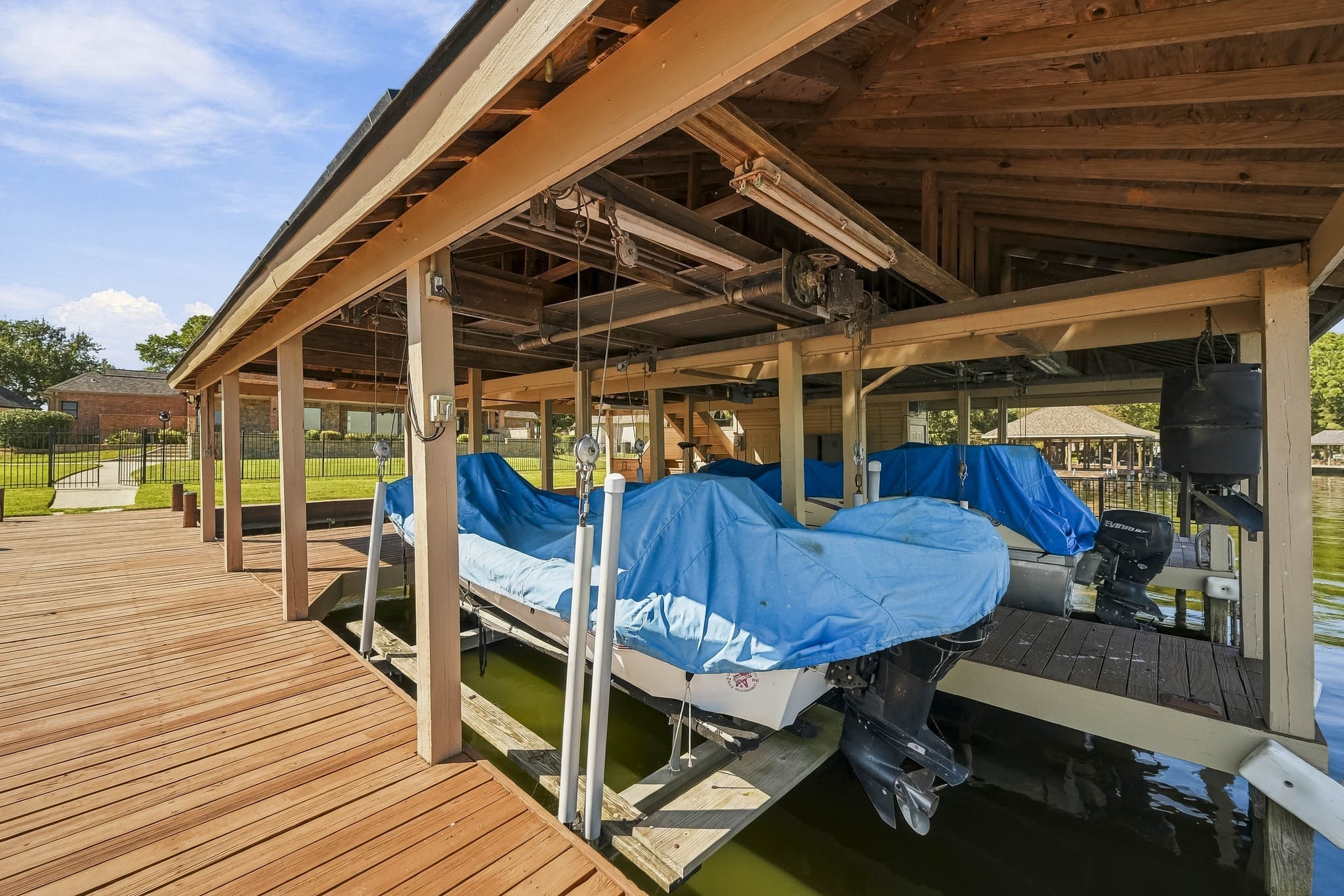 Boating enthusiasts will appreciate TWO covered boat slips with lifts and a spacious wooden dock providing convenient access to the water. Boats not included.