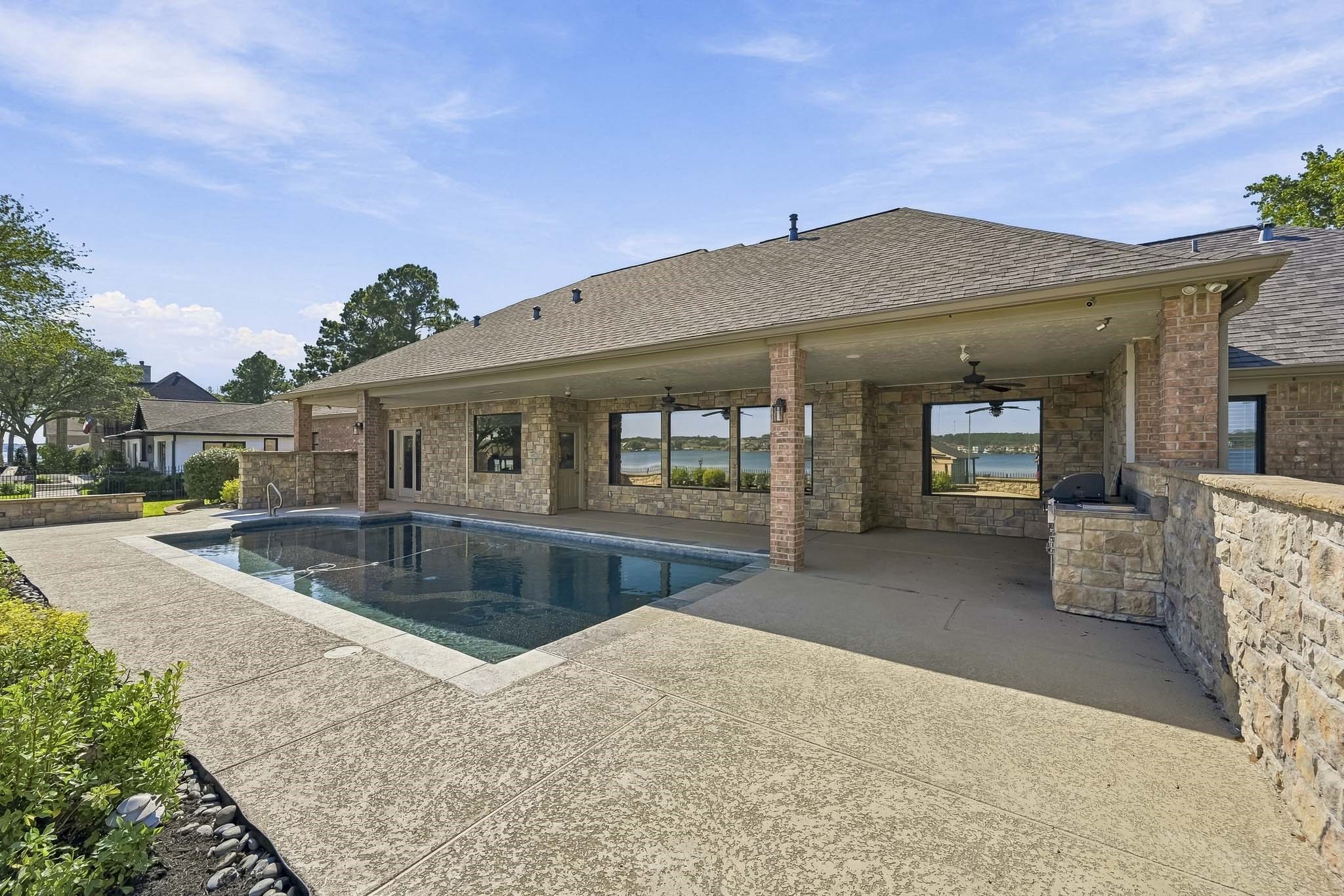 Designed for indoor-outdoor living, the covered patio extends along the home and overlooks the pool, creating an inviting space to gather and relax.
