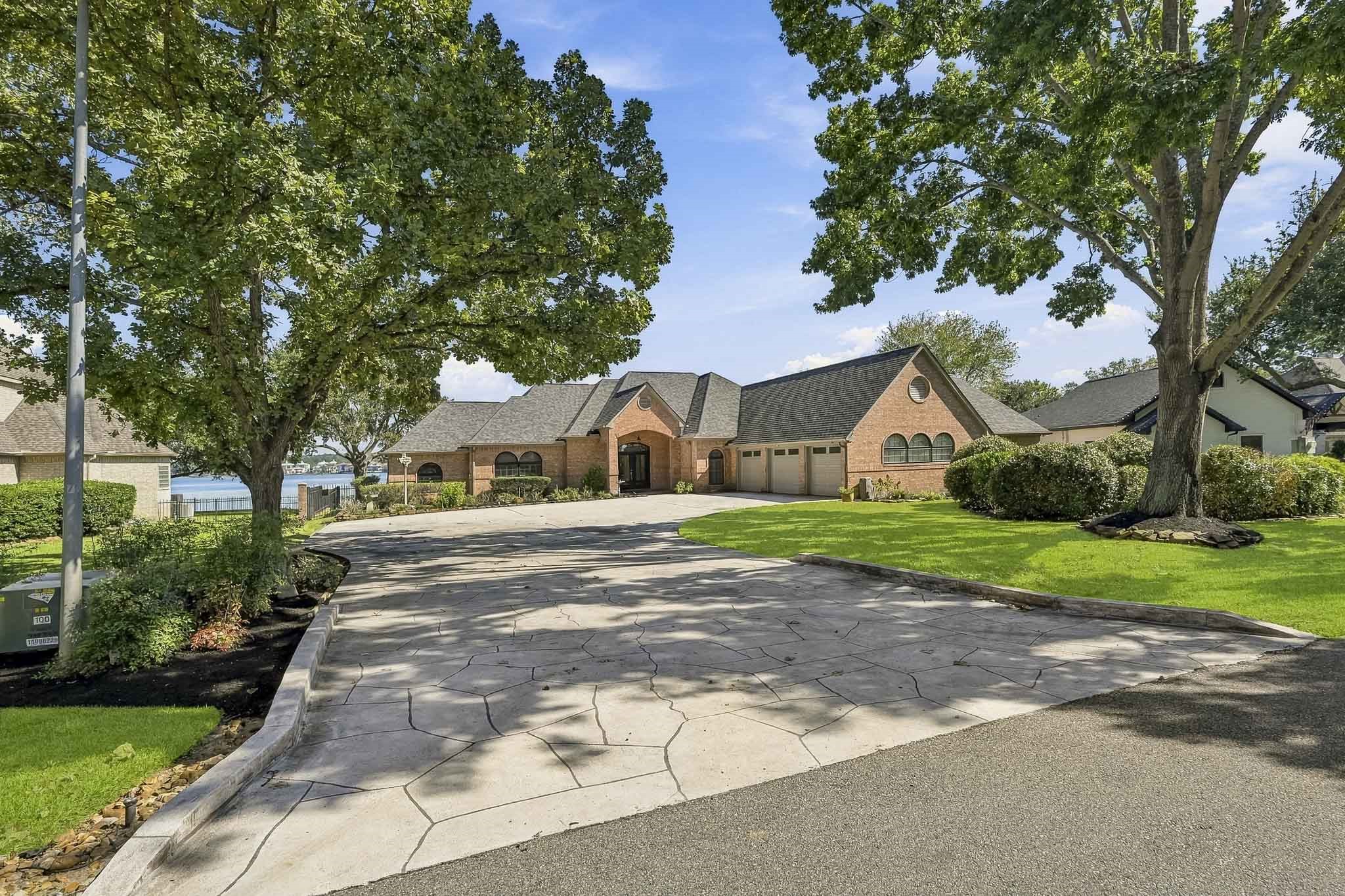 Lake life starts at the driveway. Stamped concrete, mature shade trees and lush landscaping create an inviting first impression.
