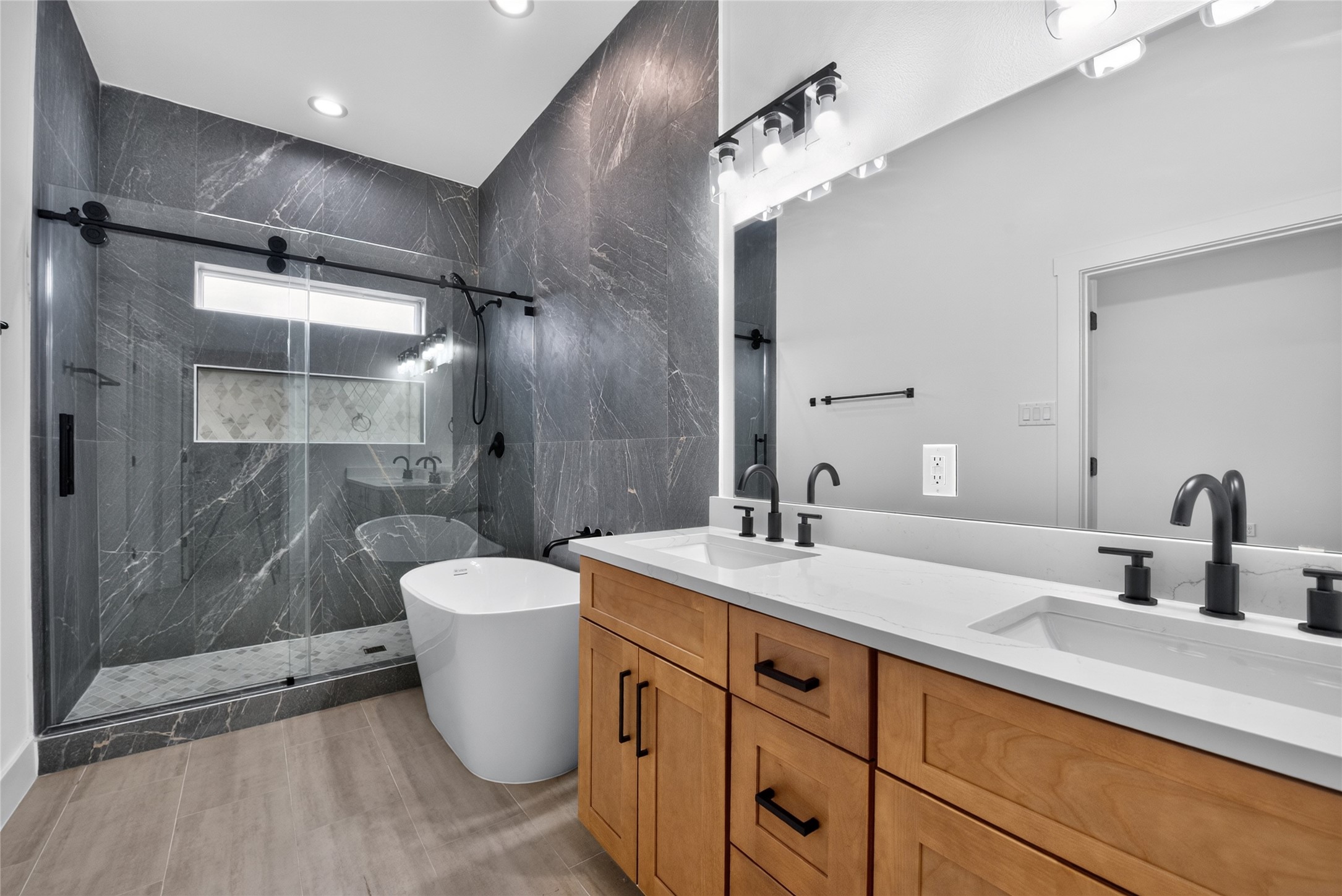 Bright, beautifully appointed, and designed to unwindfeaturing dual vanities, a relaxing soaking tub, oversized glass-enclosed shower, and transom window that brings in even more natural light. A polished retreat that brings everyday luxury home.