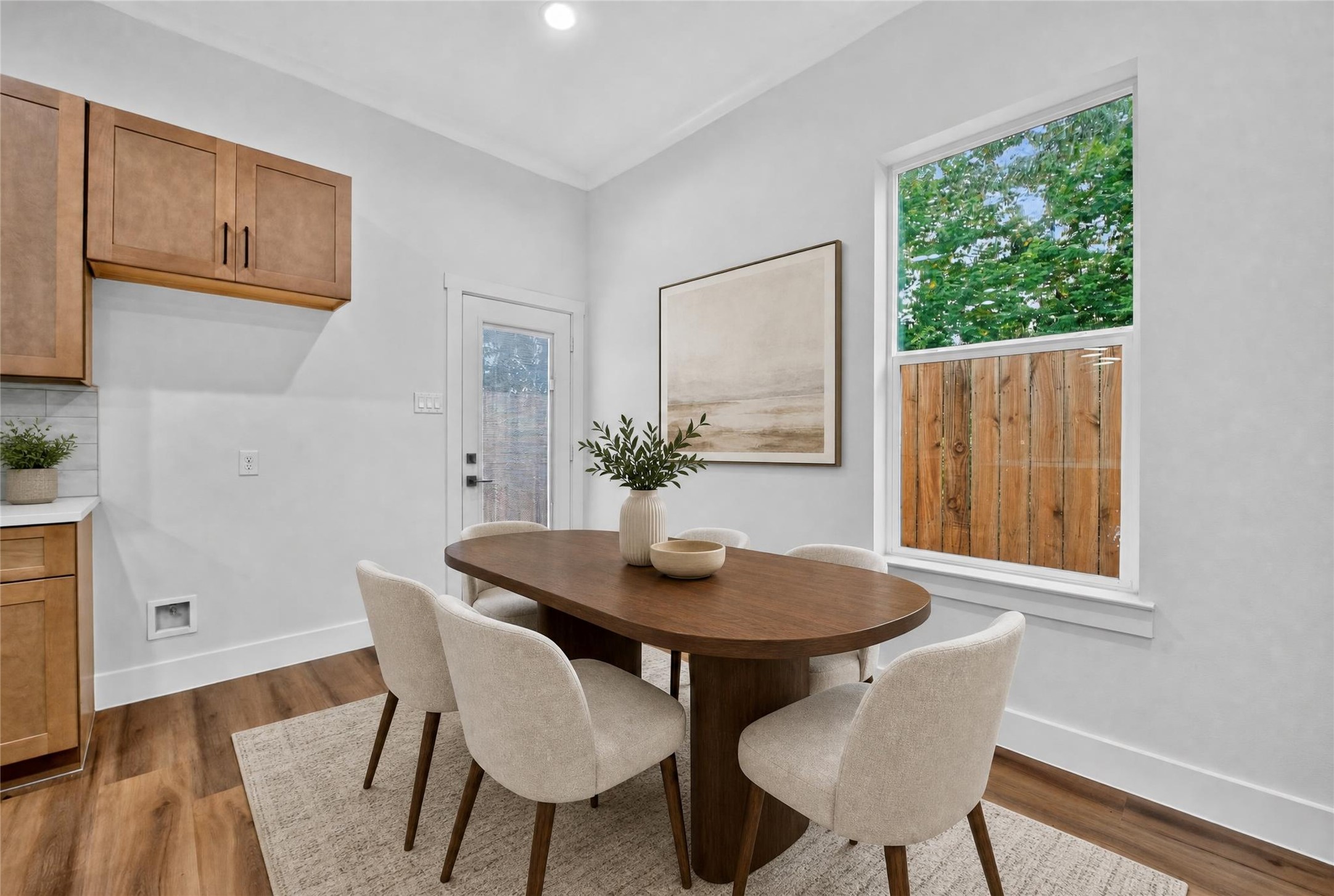 A bright, inviting dining space positioned just off the kitchen, with generous windows overlook the green space and easy access to outdoor living. A stylish setting made for everyday meals and easy entertaining.