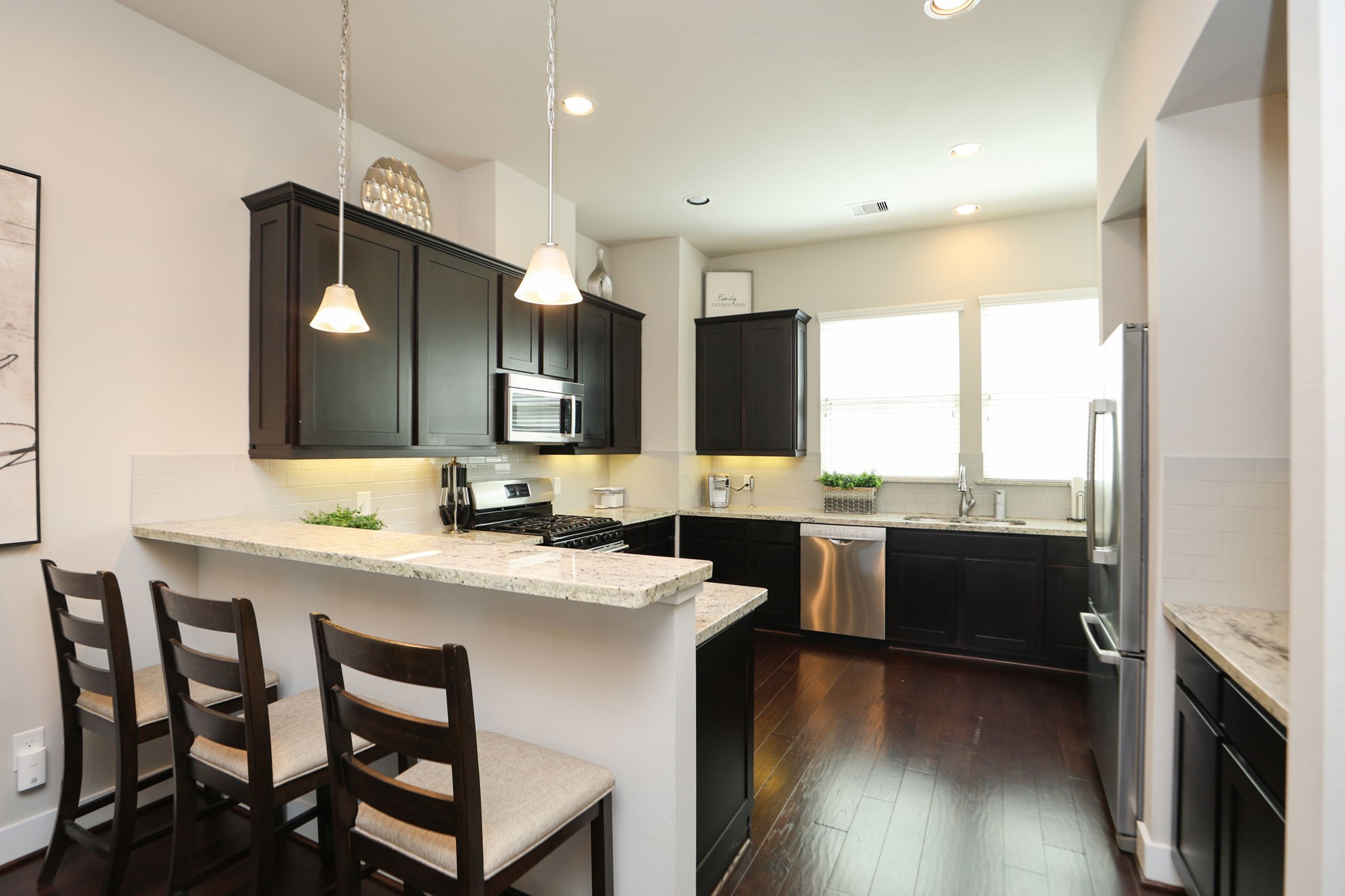 Large kitchen features light granite countertops, a gas range, wine fridge, dry bar, and large windows over your sink - with plenty of room to prepare meals!