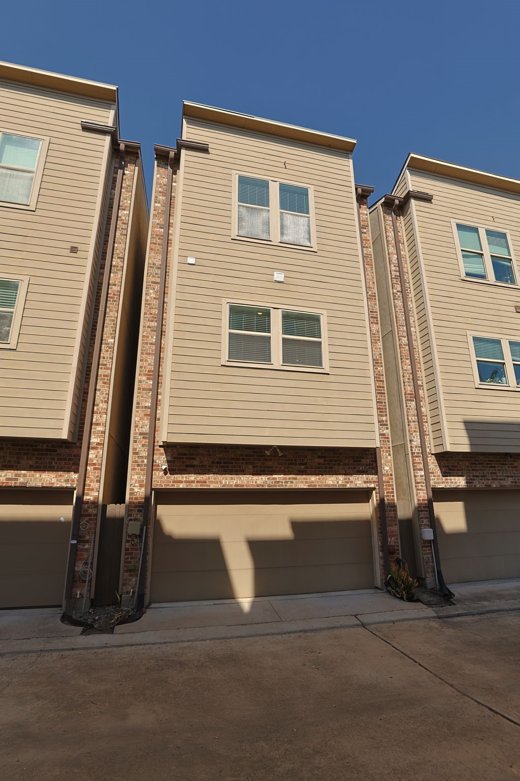 View of rear of home from the shared, gated driveway. Very new development inside the loop with easy access to EVERYTHING!!