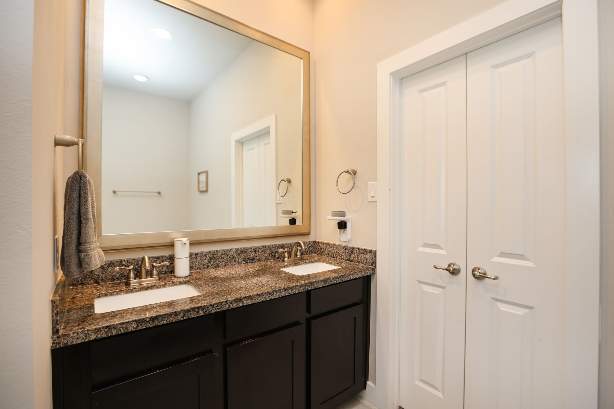 Double vanity in primary bath with double doors to your large closet. Behind you is your soaking tub and glass-enclosed shower.
