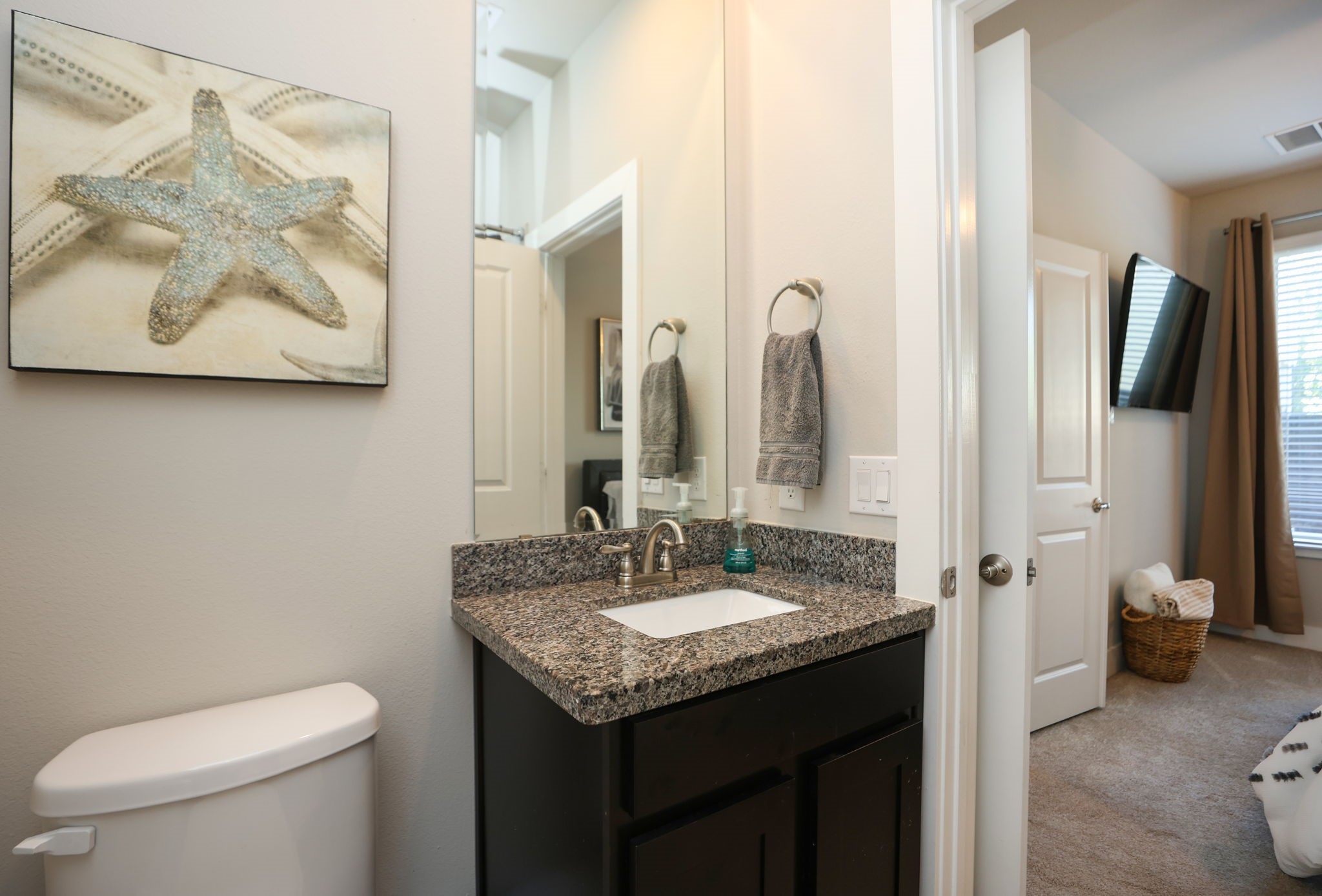 First floor full bath featuring granite countertops and a shower/tub combo. View towards the bedroom and windows.
