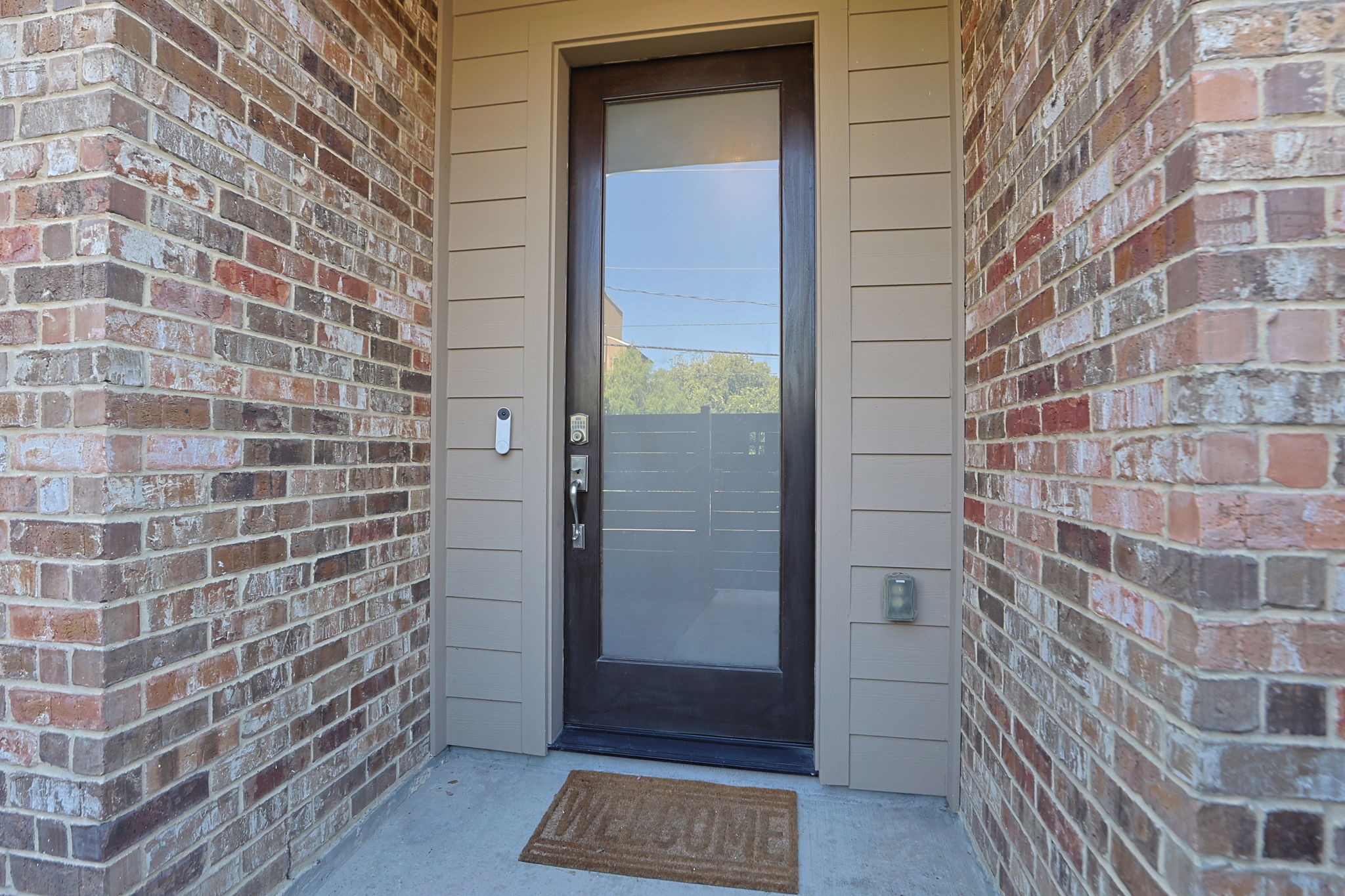 Solid wood modern front door with glass and a keyless entry. Guests are covered from the rain at your entrance!