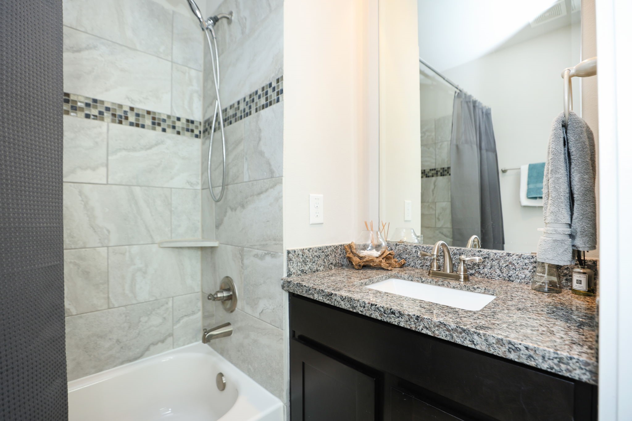 3rd full bath with tub/shower combo, modern tile, granite countertops, and dark wood cabinetry. Whole home feels modern and very clean!