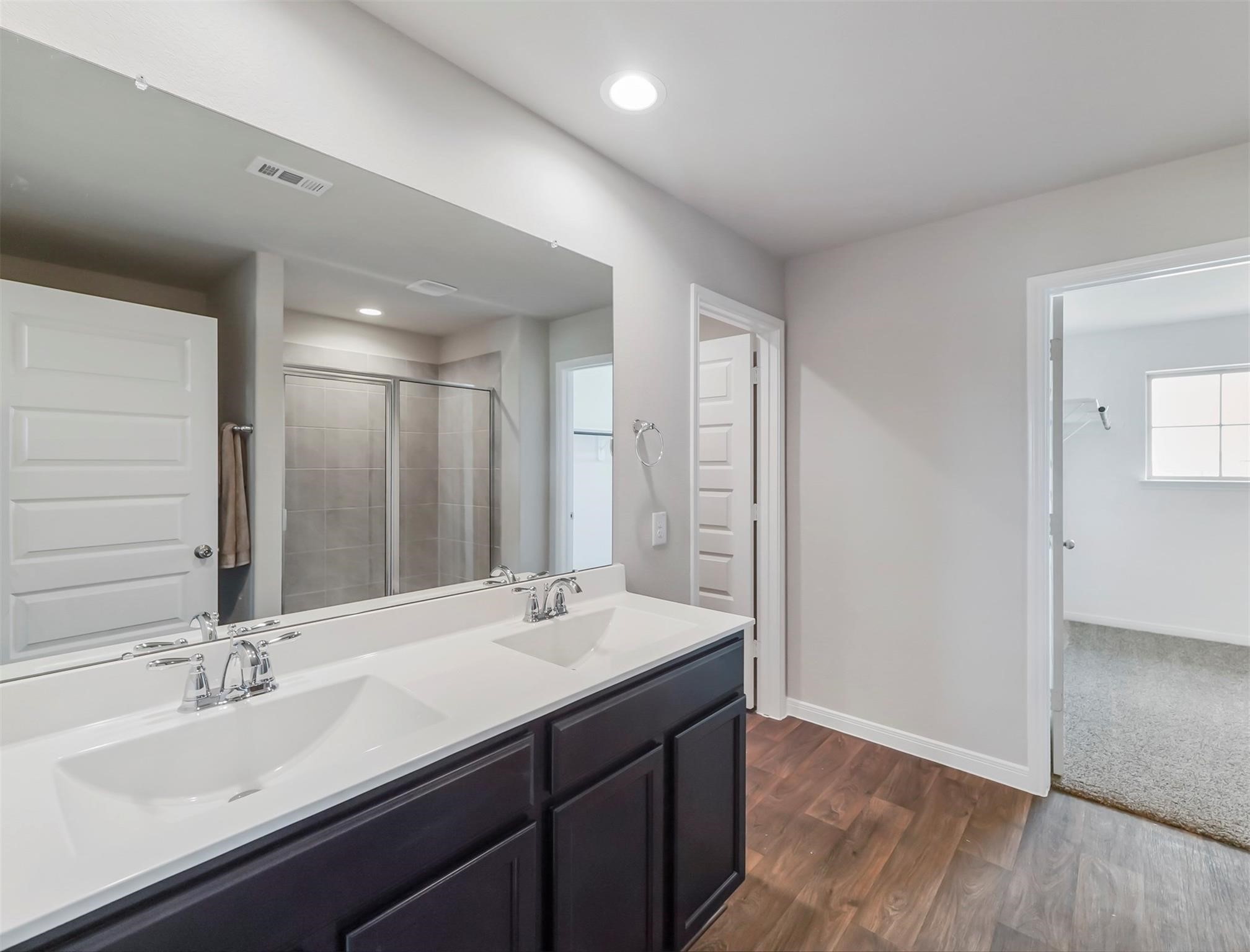 Private primary bath with an oversized walk-in shower and plenty of storage space.