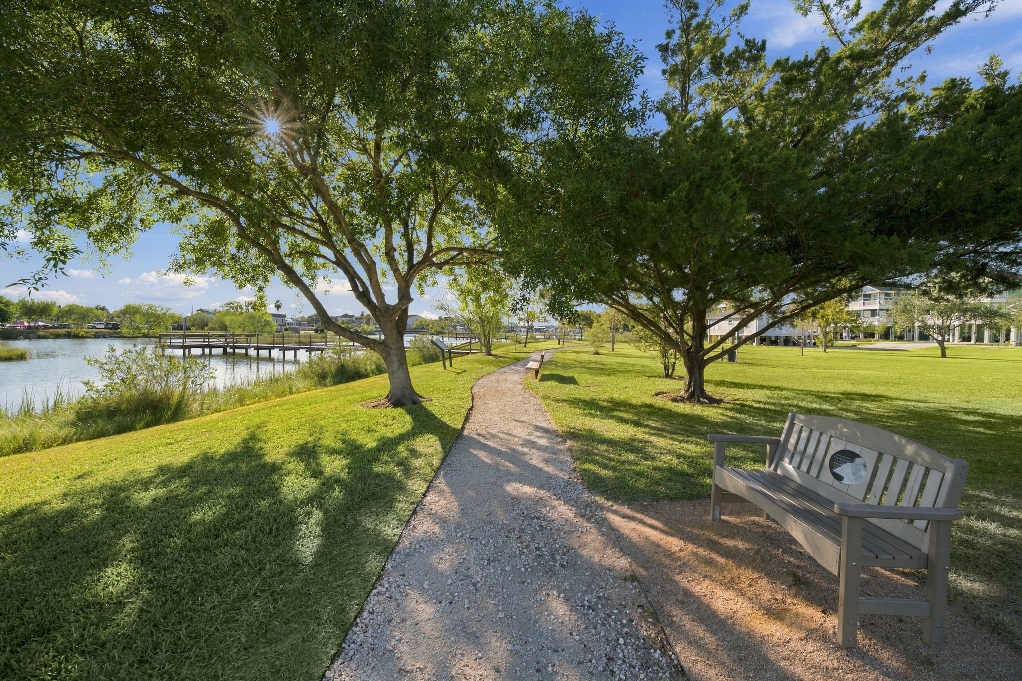 A serene pathway winds through one of the many parks  offering picturesque views of a tranquil lake and a charming wooden dock.