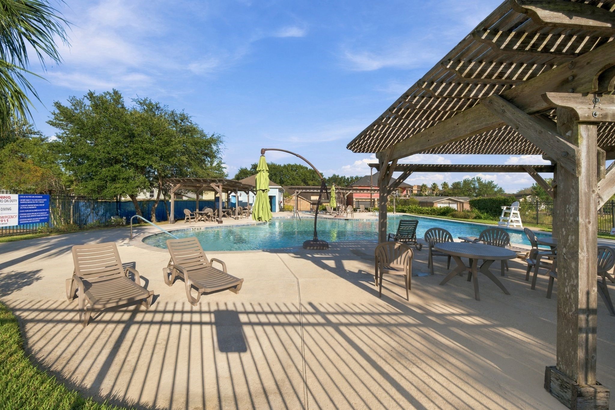 The neighborhood has inviting pool area, featuring ample lounging space and a charming pergola for shaded relaxation.