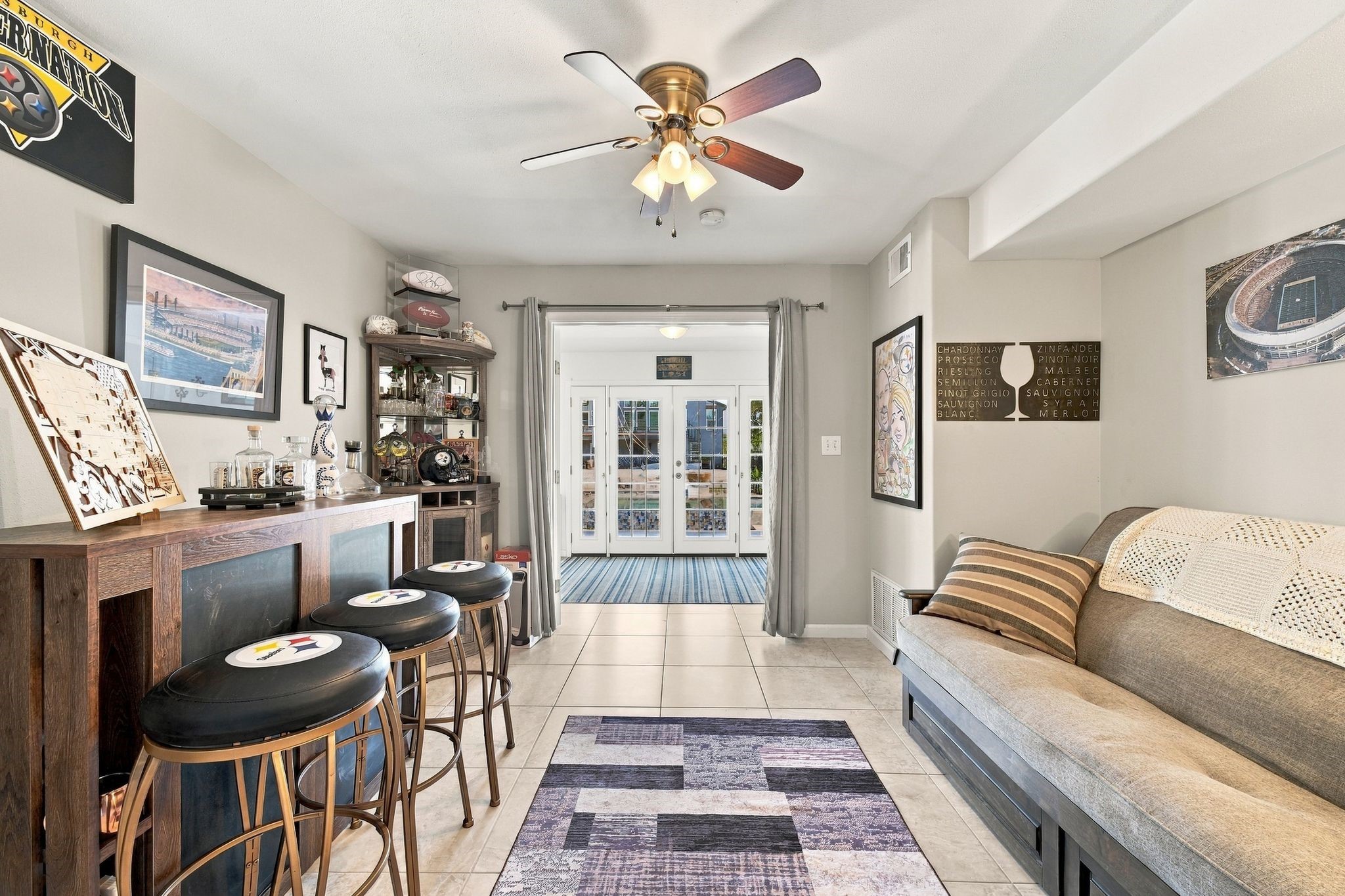 This charming entertainment space is the perfect lounge to watch the game while overlooking the pool and waterfront through elegant French doors.