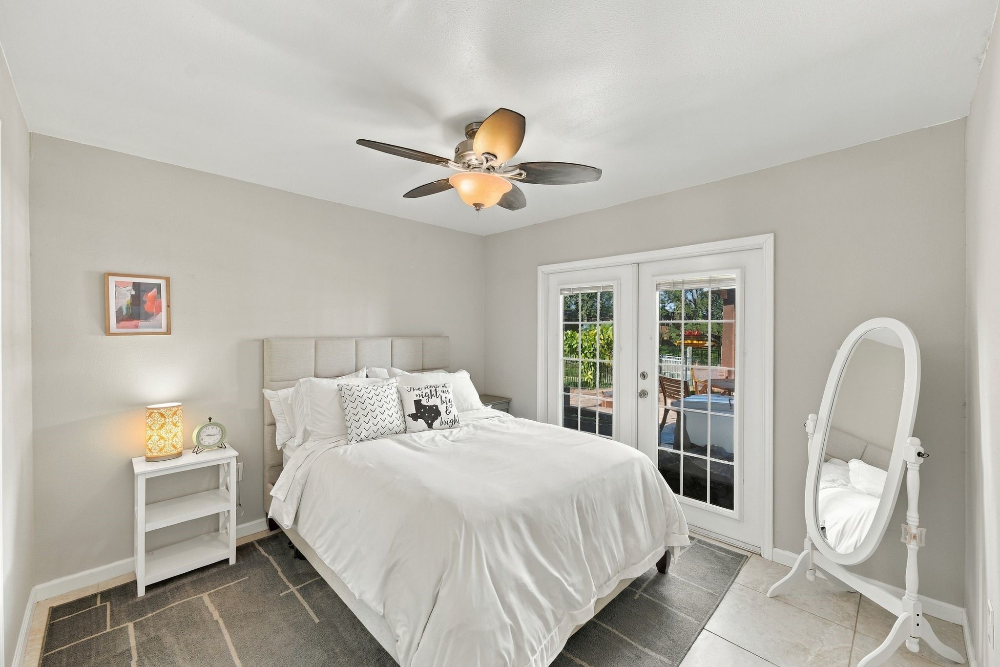 The secondary bedroom is located on the first floor, shares a Jack N Jill bathroom, and has Cozy  French doors leading the serene pool and waterfront.