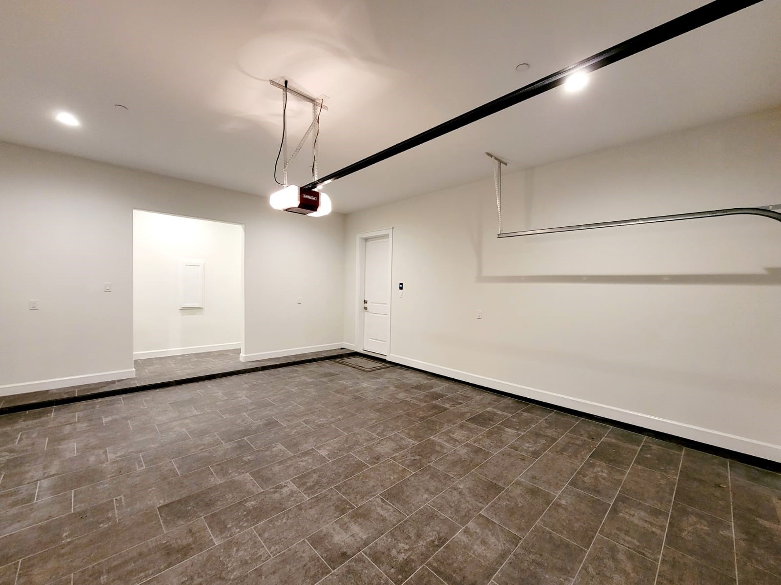 Large garage with amaIng flooring, extra storage and showroom lighting. 12 ft ceilings 220V plug for electric vehicle charge, WIFI garage door