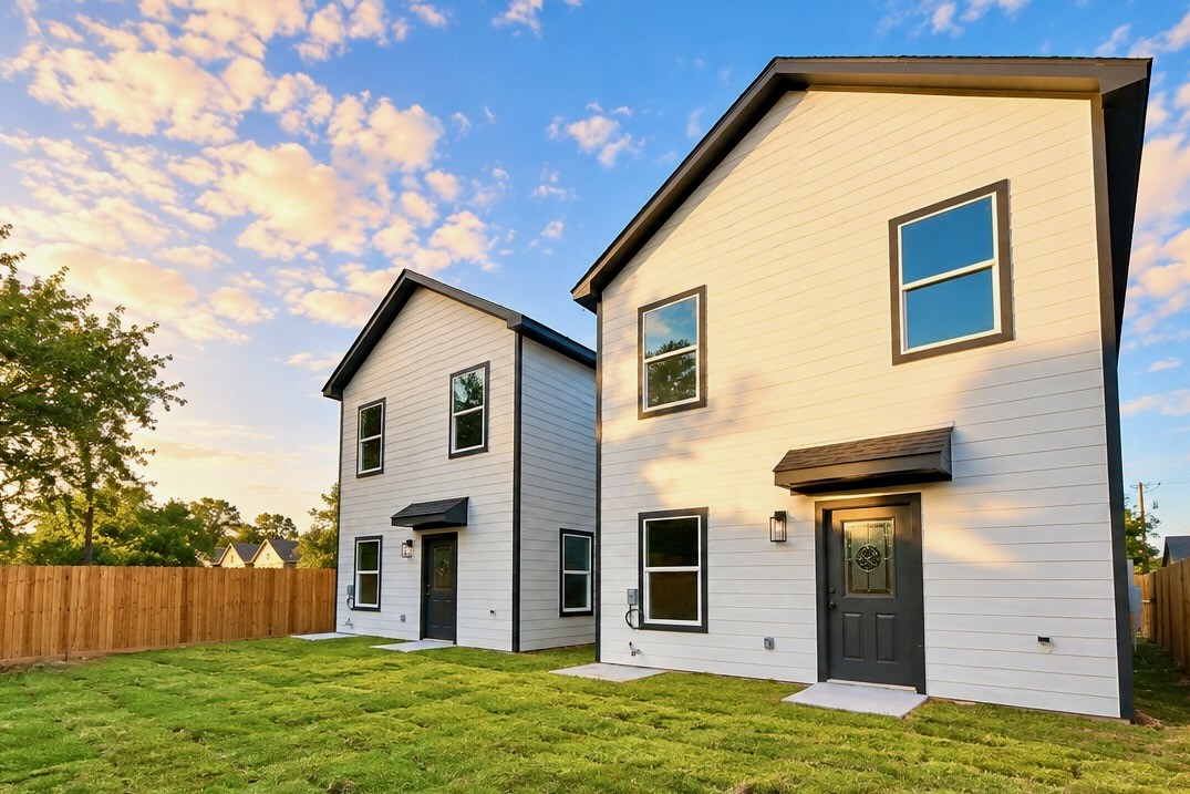 Another view of the backyard highlights the fully fenced outdoor area and the home's two-story rear elevation. The manageable yard provides room to enjoy the outdoors without extensive upkeep.