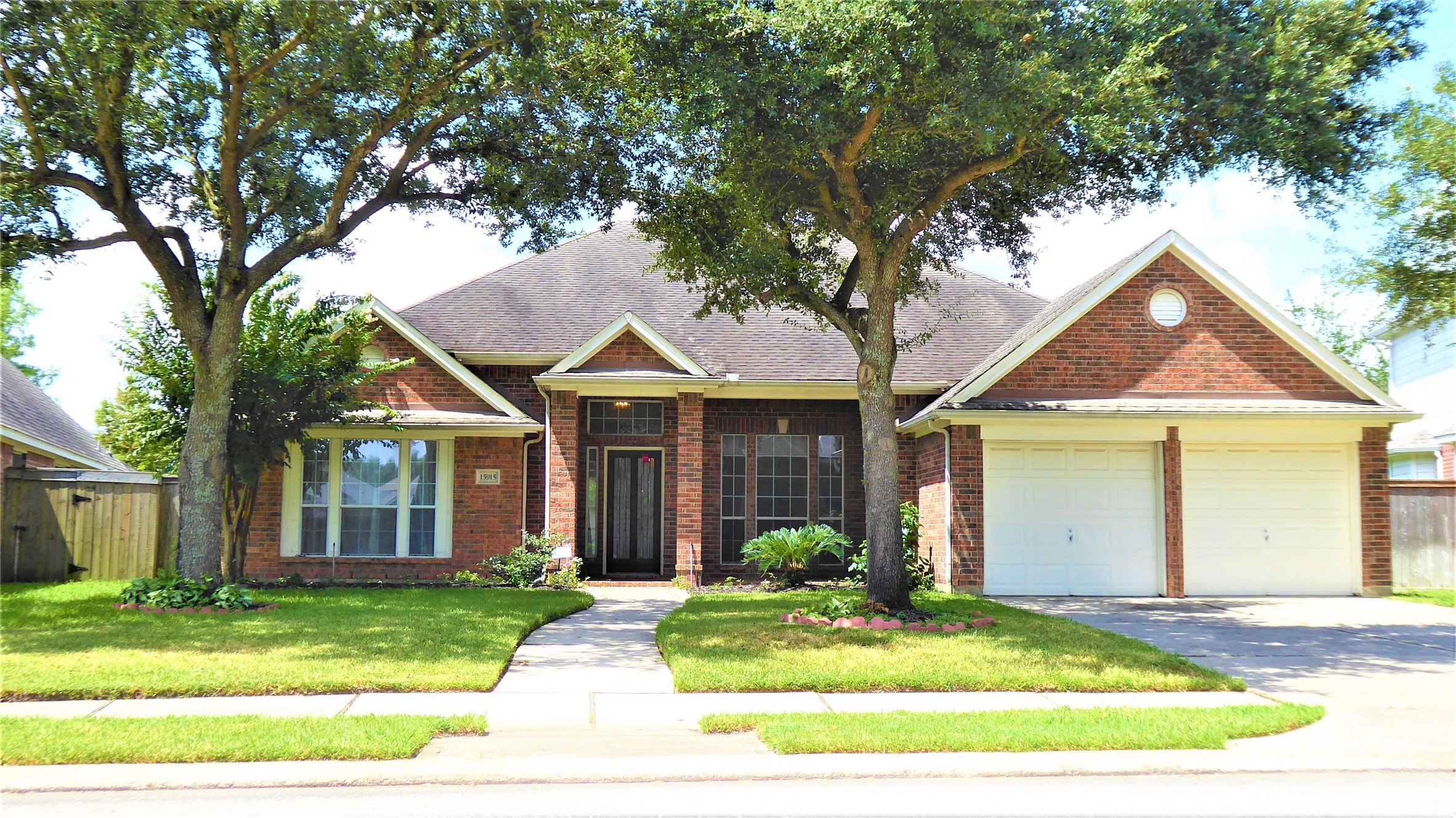 Home Sweet Home, with mature live oak trees in front