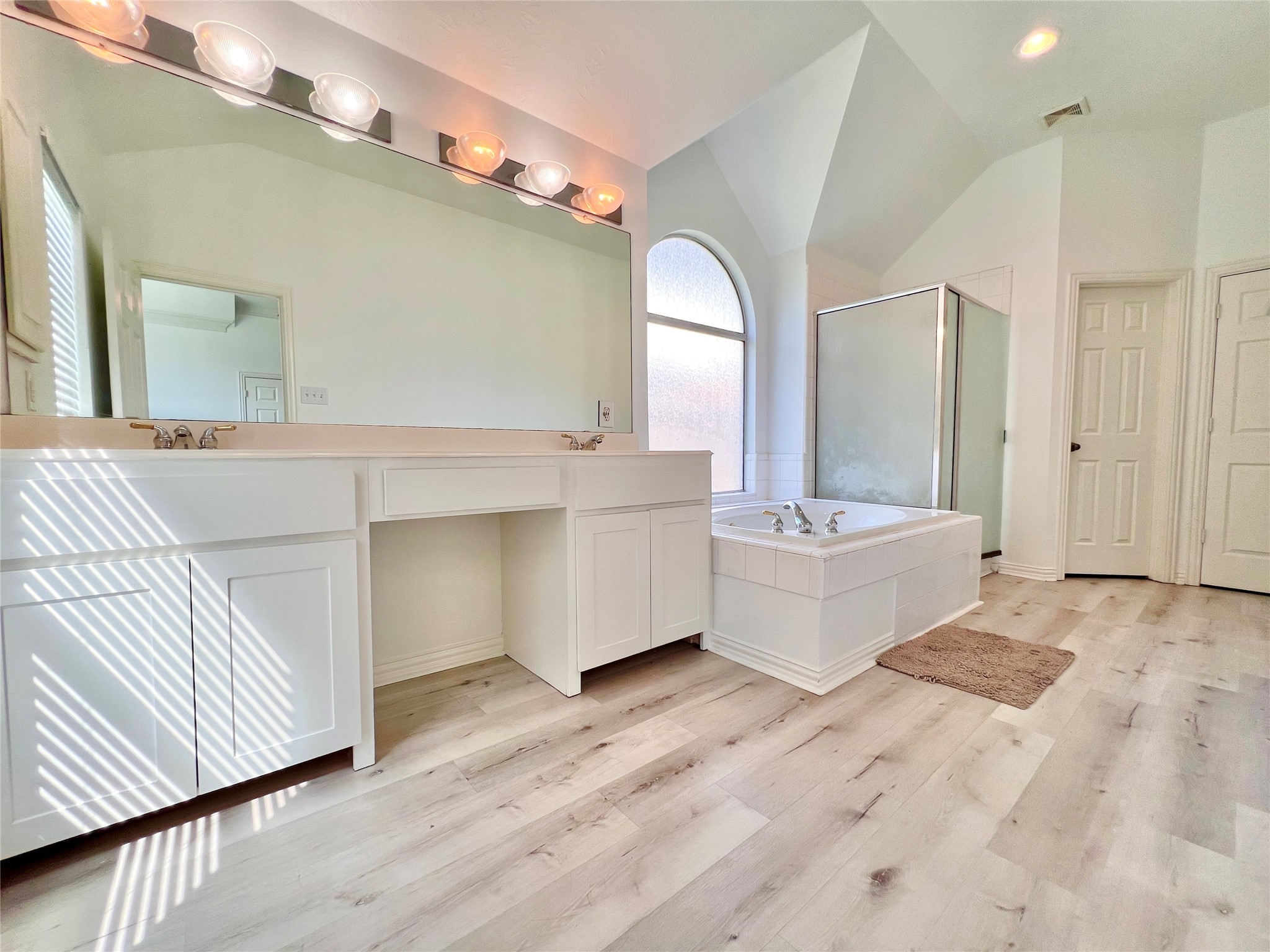 Primary bath has ,a Long vanity counter with double Sink, and make up desk
