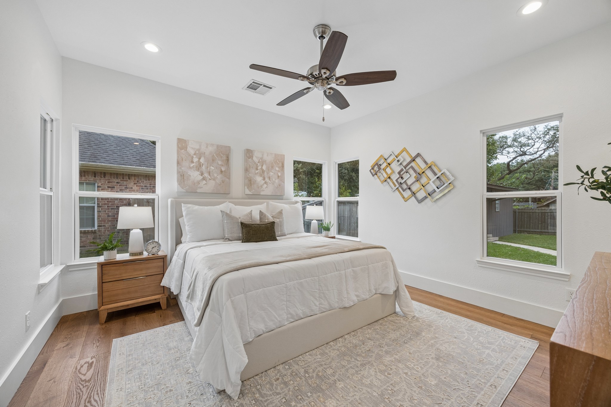 Primary bedroom featuring large windows offering plenty of natural light and views of the spacious backyard.