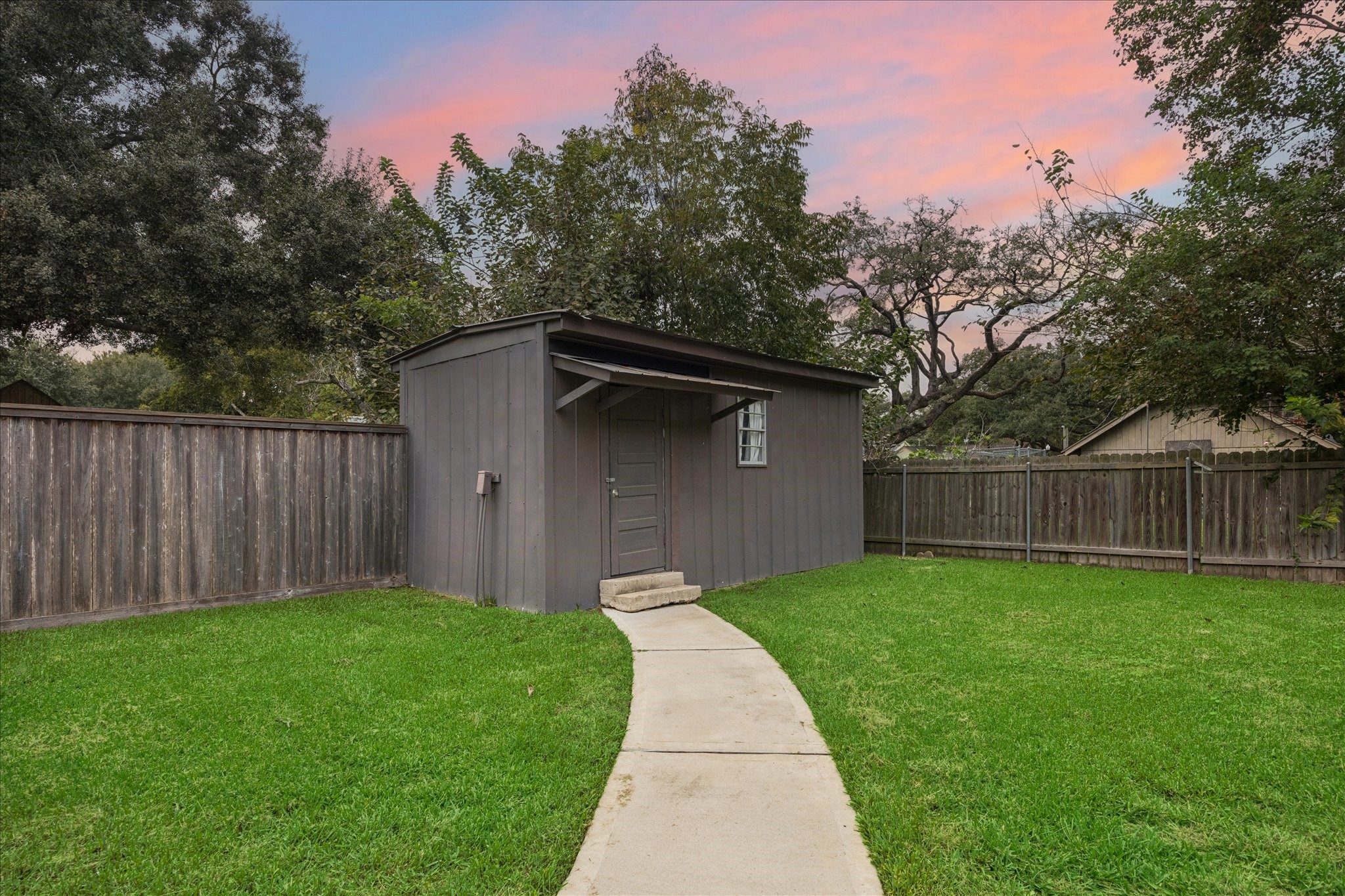 Spacious storage building in the back corner of the yard.