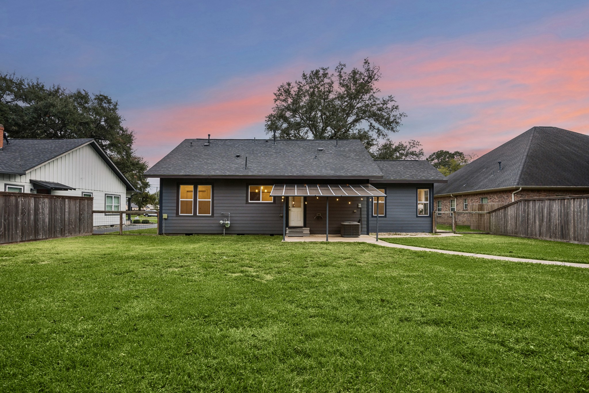 Charming backyard with a spacious lawn and a cozy covered patio, perfect for outdoor relaxation.