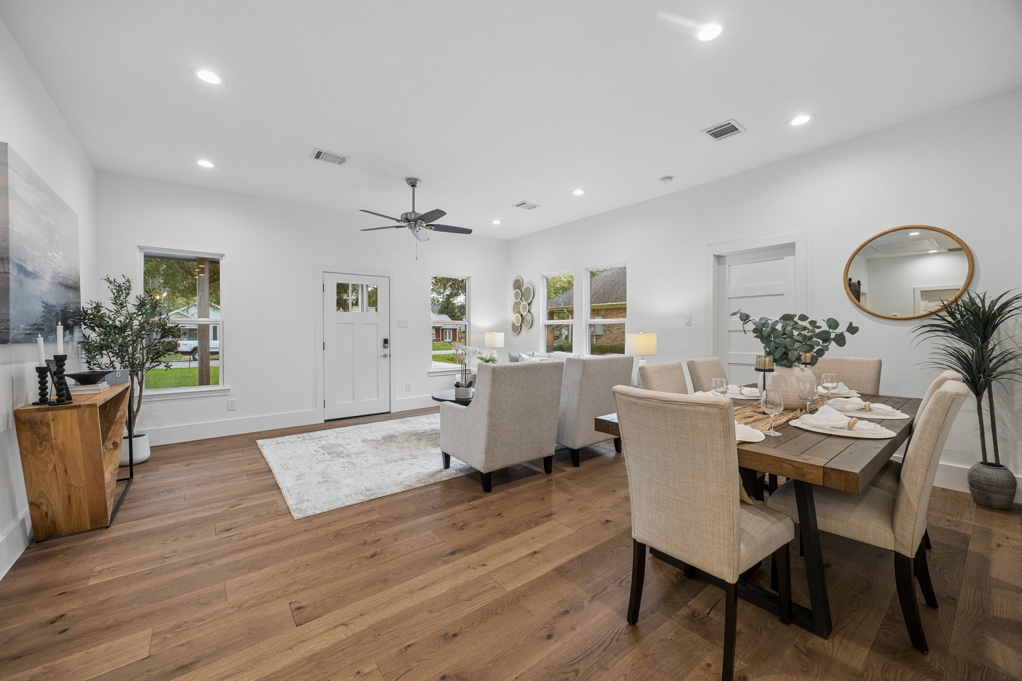 Open-concept living and dining area features elegant wood flooring, neutral tones, and ample natural light, creating a warm and welcoming atmosphere.