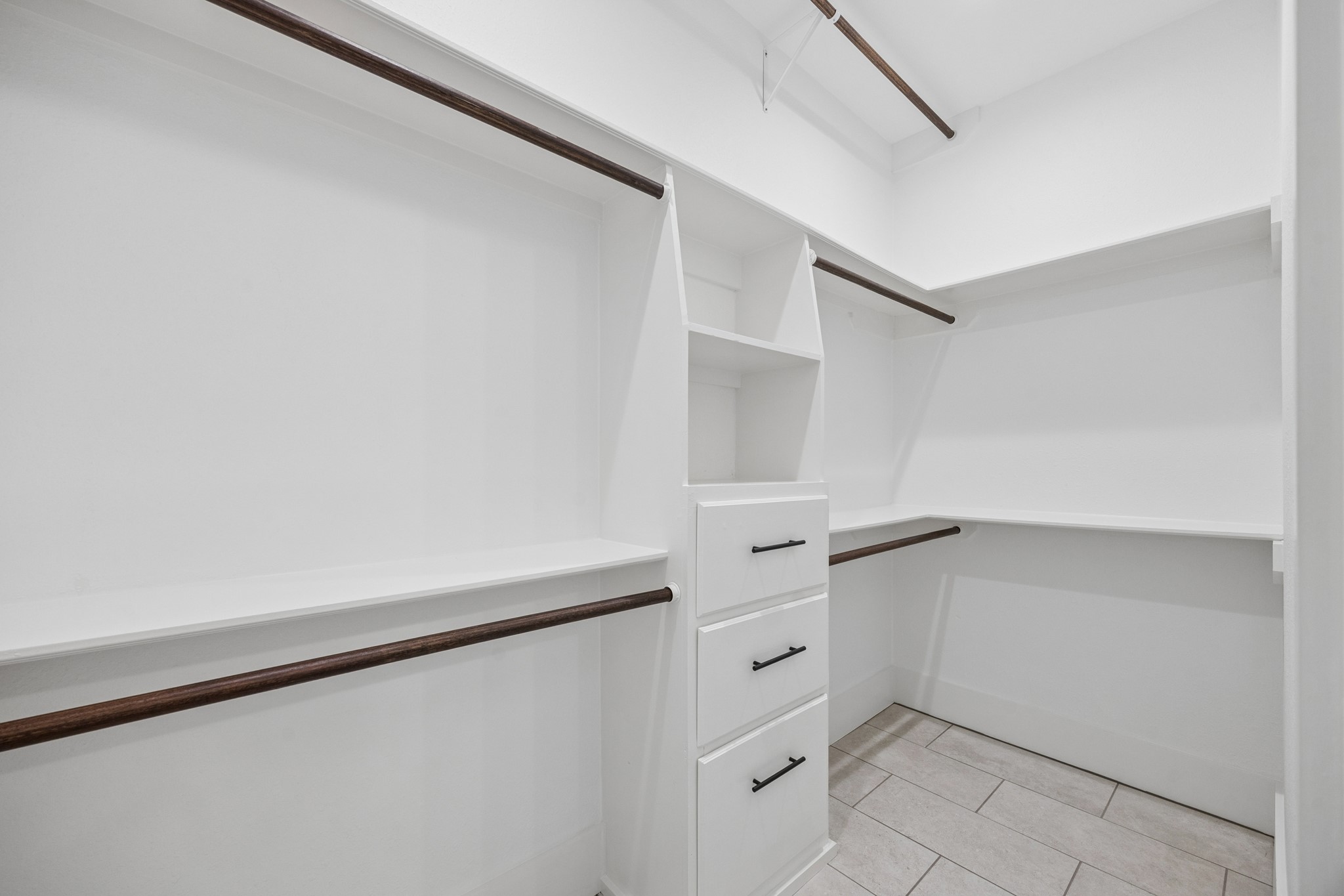 Spacious walk-in closet with ample shelving, hanging space, and built-in drawers for organized storage.