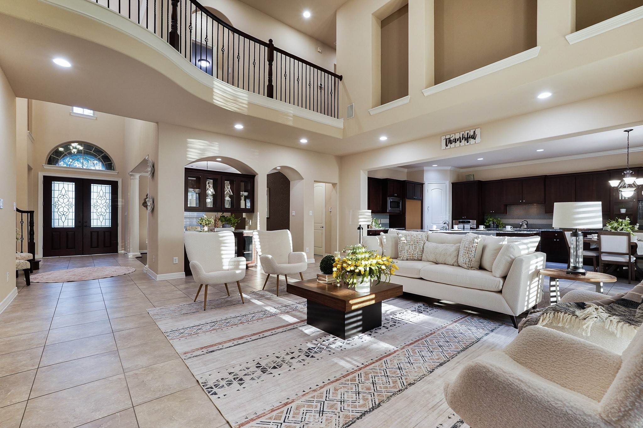 This elegant home features a two-story family room with abundant natural light, open floor plan, and a stylish kitchen. A grand entrance and balcony enhance the luxurious feel.