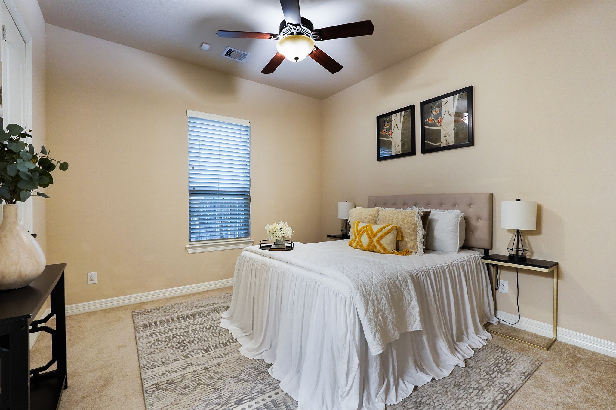 FIRST Flr-2nd bedroom down: This cozy bedroom features neutral walls, a ceiling fan, and ample natural light from a single window.