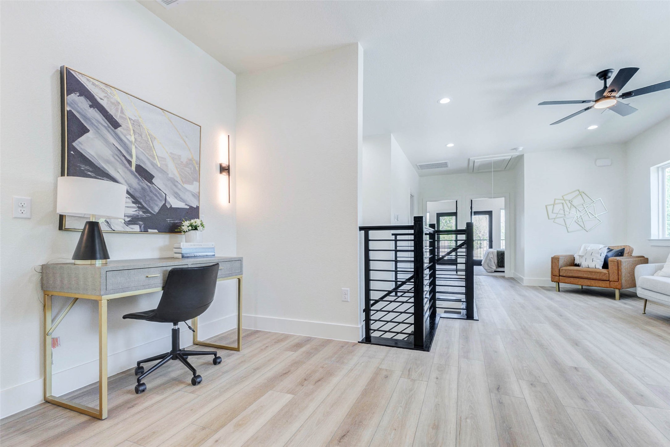 Versatile wide-plank flooring extends throughout the upstairs landing, which includes dedicated wall space for a workstation or console.