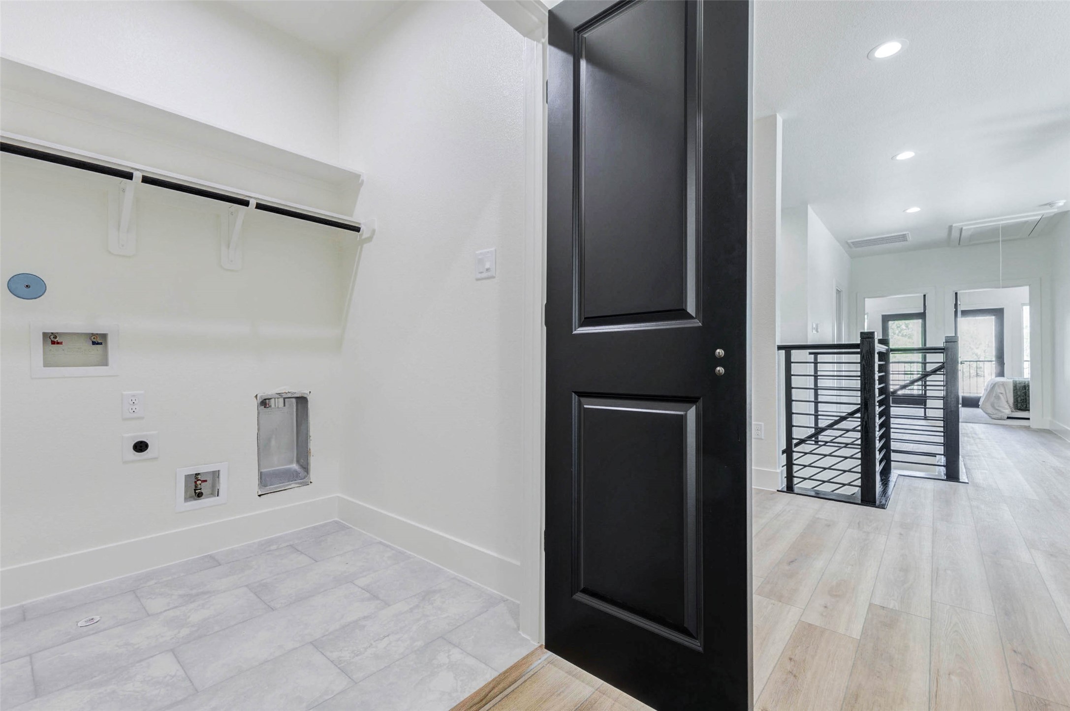 A dedicated laundry room provides convenient tile flooring, built-in shelving, and pre-installed hookups for a washer and dryer.