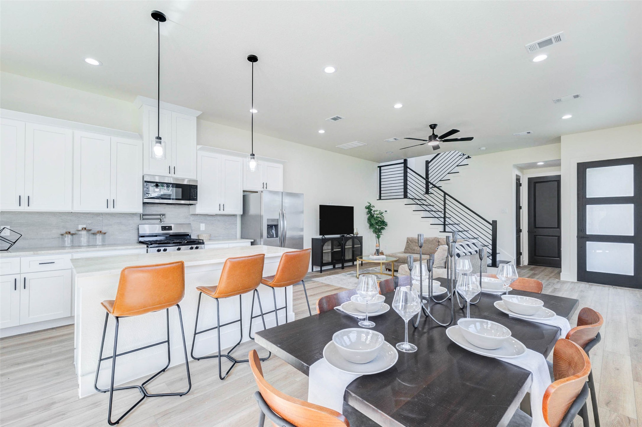 A chef-inspired kitchen boasts white Shaker-style cabinetry, light stone countertops, and a full suite of stainless steel appliances. A chef-inspired kitchen boasts white Shaker-style cabinetry, light stone countertops, and a full suite of stainless steel appliances.
