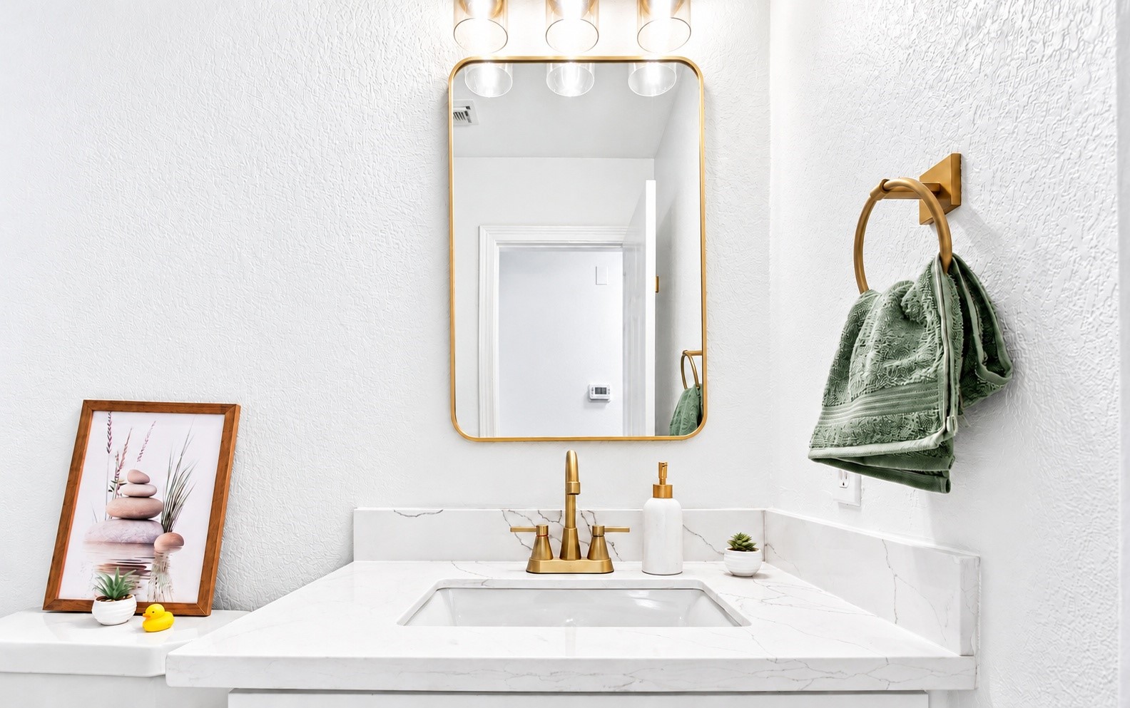 The bathroom vanity with new gold plumbing fixtures!