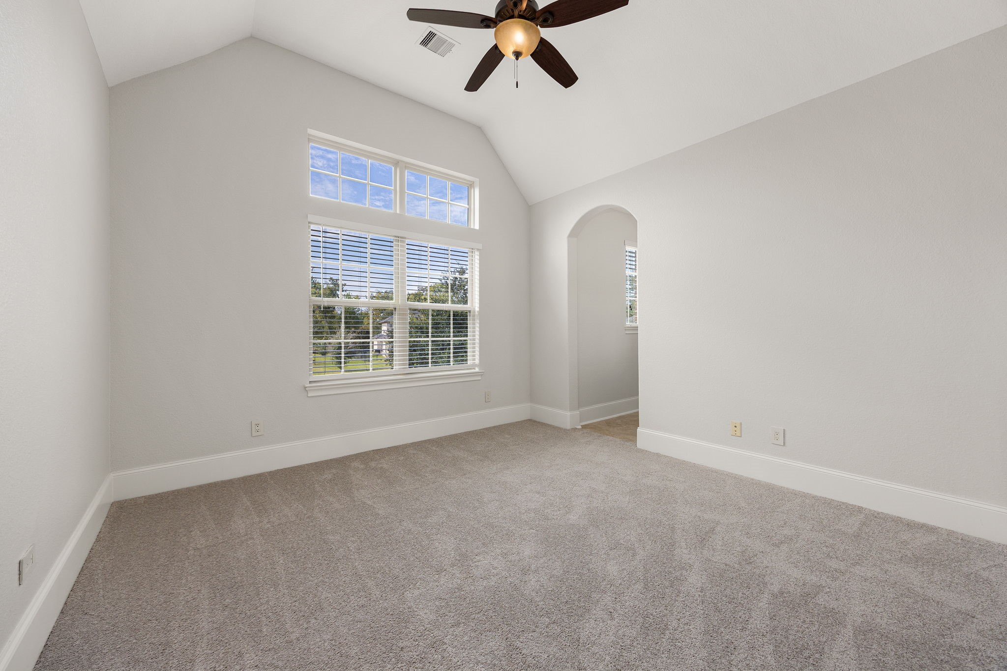 Rounding out the upper level, the fifth bedroom offers abundant natural light, with an arched doorway adding architectural charm.