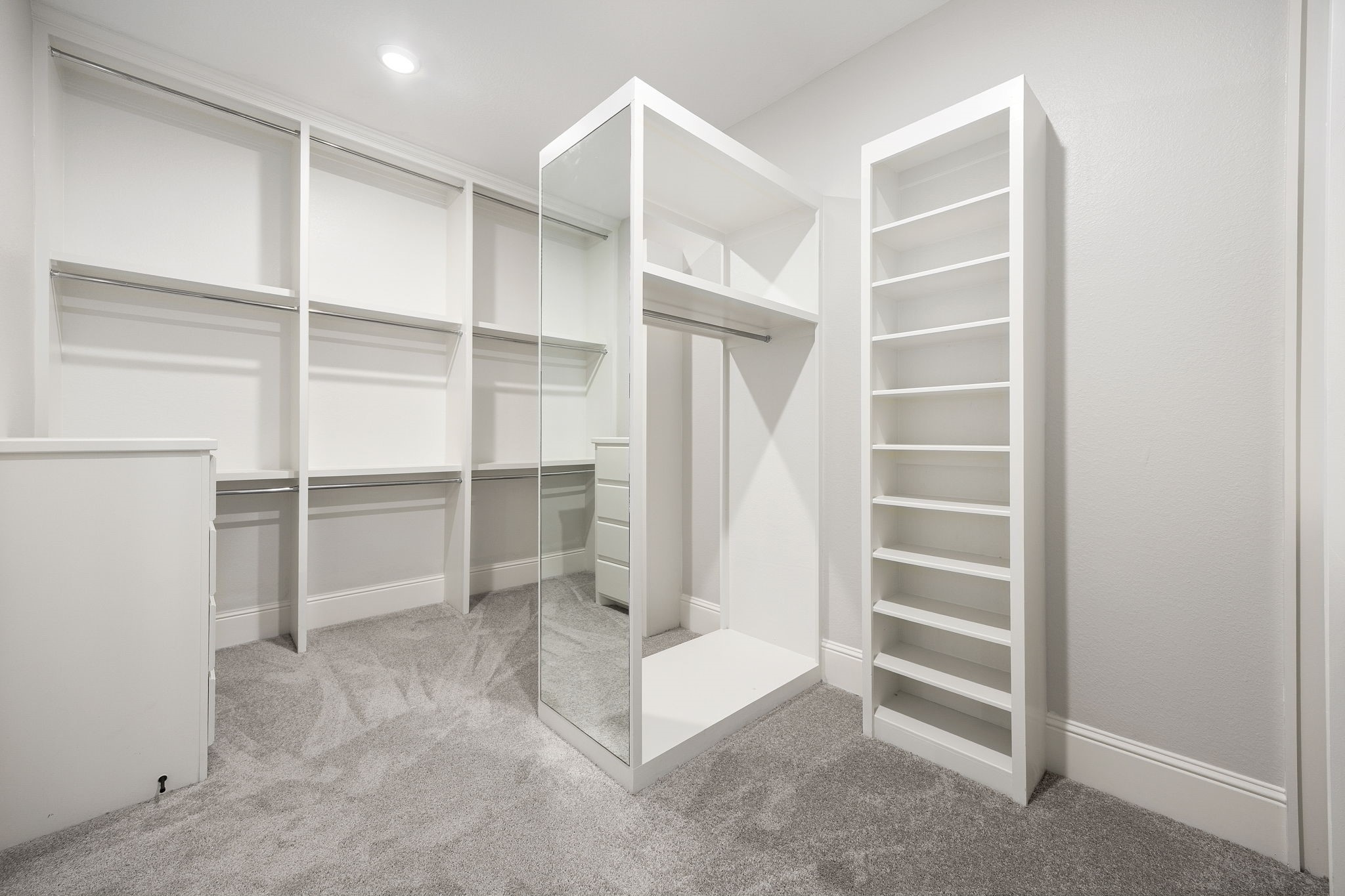 The primary closet is a study in organization, offering expansive custom shelving, abundant hanging space, and a mirrored accent for the ultimate dressing experience.