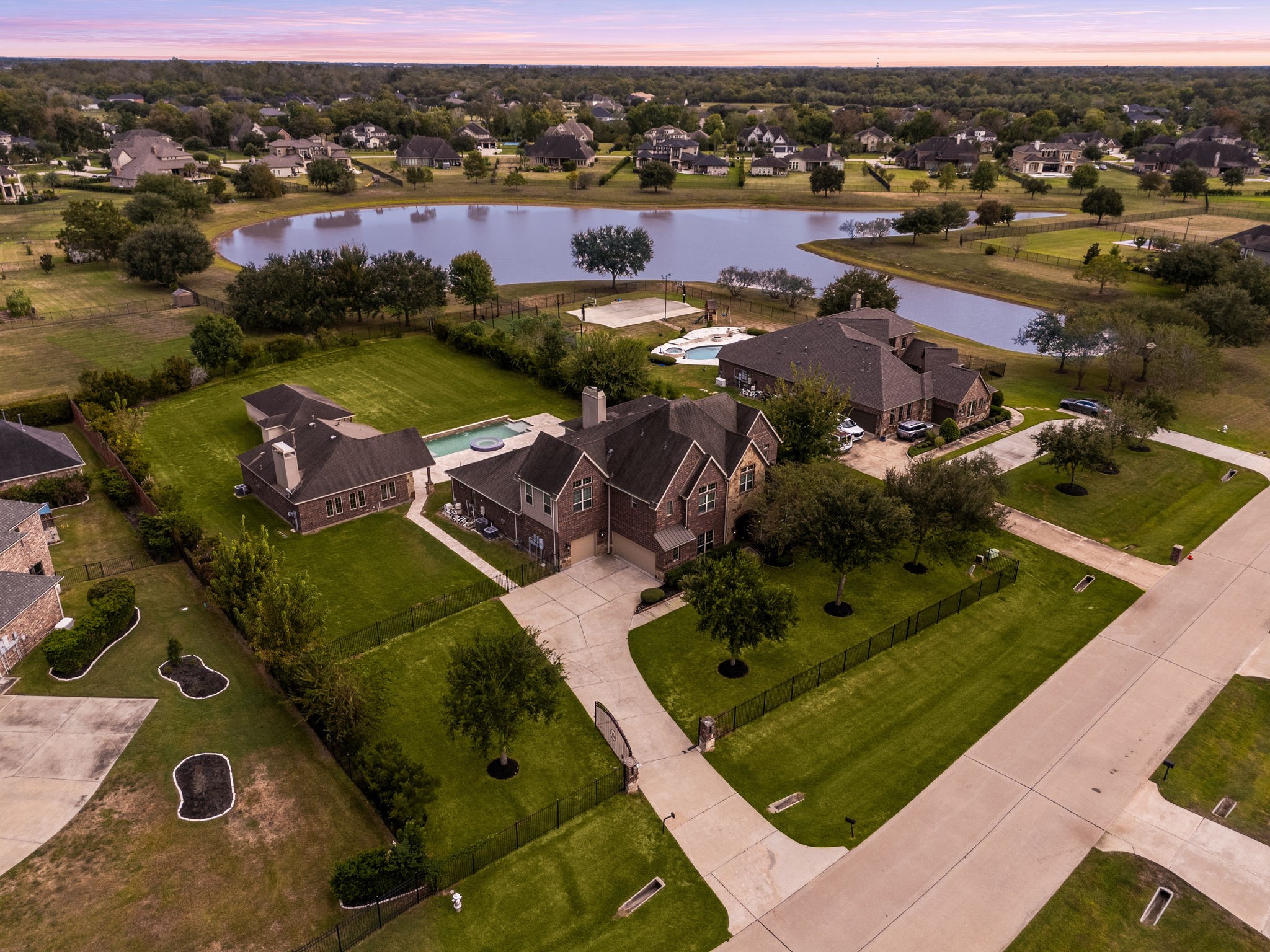 This twilight aerial view captures the full scope of the estate, the main residence, detached casita, and resort-style pool all set against the backdrop of the private, acre-plus lot and surrounding community. This twilight aerial view captures the full scope of the estate, the main residence, detached casita, and resort-style pool all set against the backdrop of the private, acre-plus lot and surrounding community.