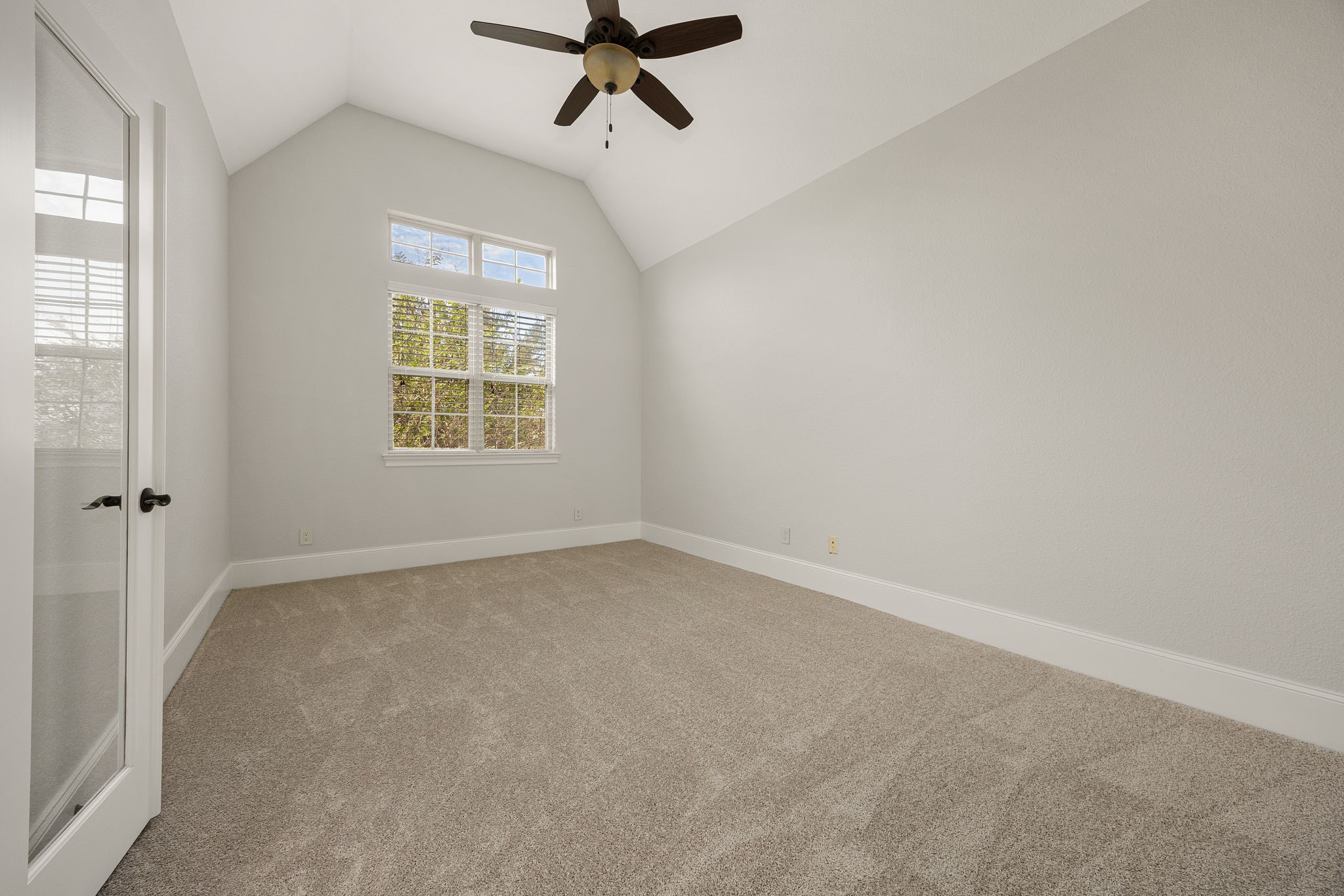 This versatile room offers soaring vaulted ceilings and abundant natural light, ideal as a second living area, home office, or private study.