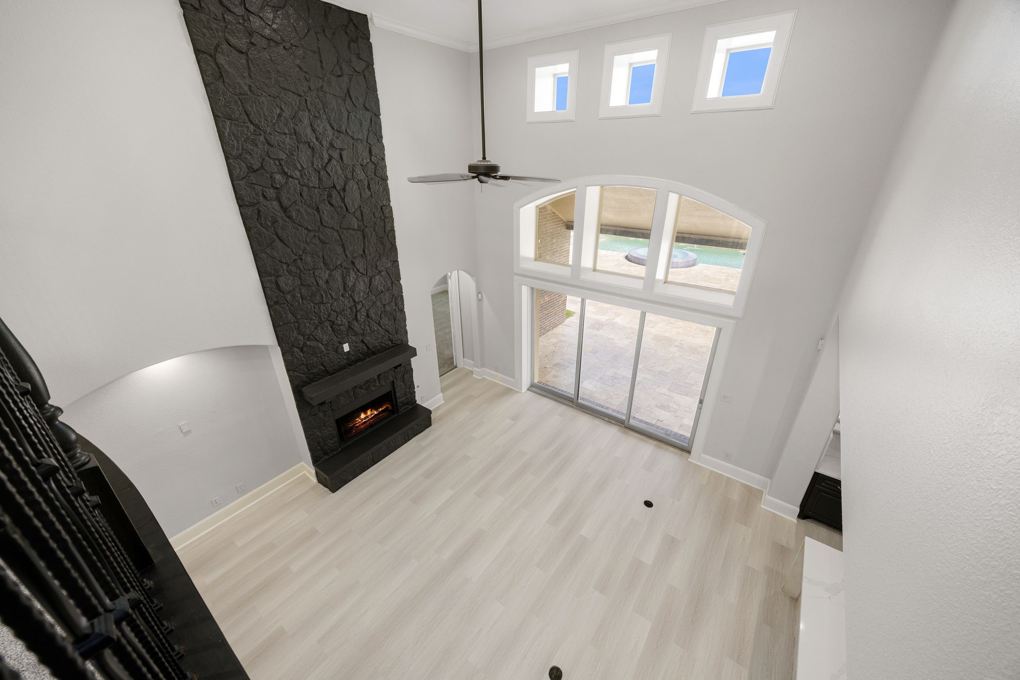 From the second-floor landing, the two-story stone fireplace and wall of windows frame sweeping views of the resort-style pool below, a true statement of scale and luxury.