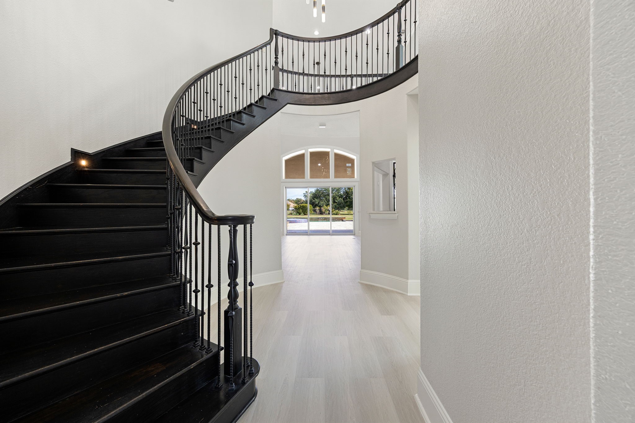 A sculptural curved staircase sets a dramatic tone from the moment you enter, follow it up to discover the gameroom and bonus room/office above.