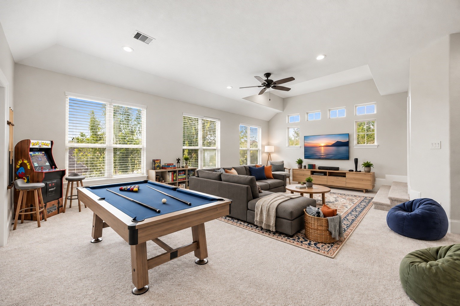 The expansive upstairs gameroom offers soaring ceilings and an abundance of natural light through a wall of windows, generous space for a pool table, lounge seating, or a private retreat of your own design. Virtually staged.