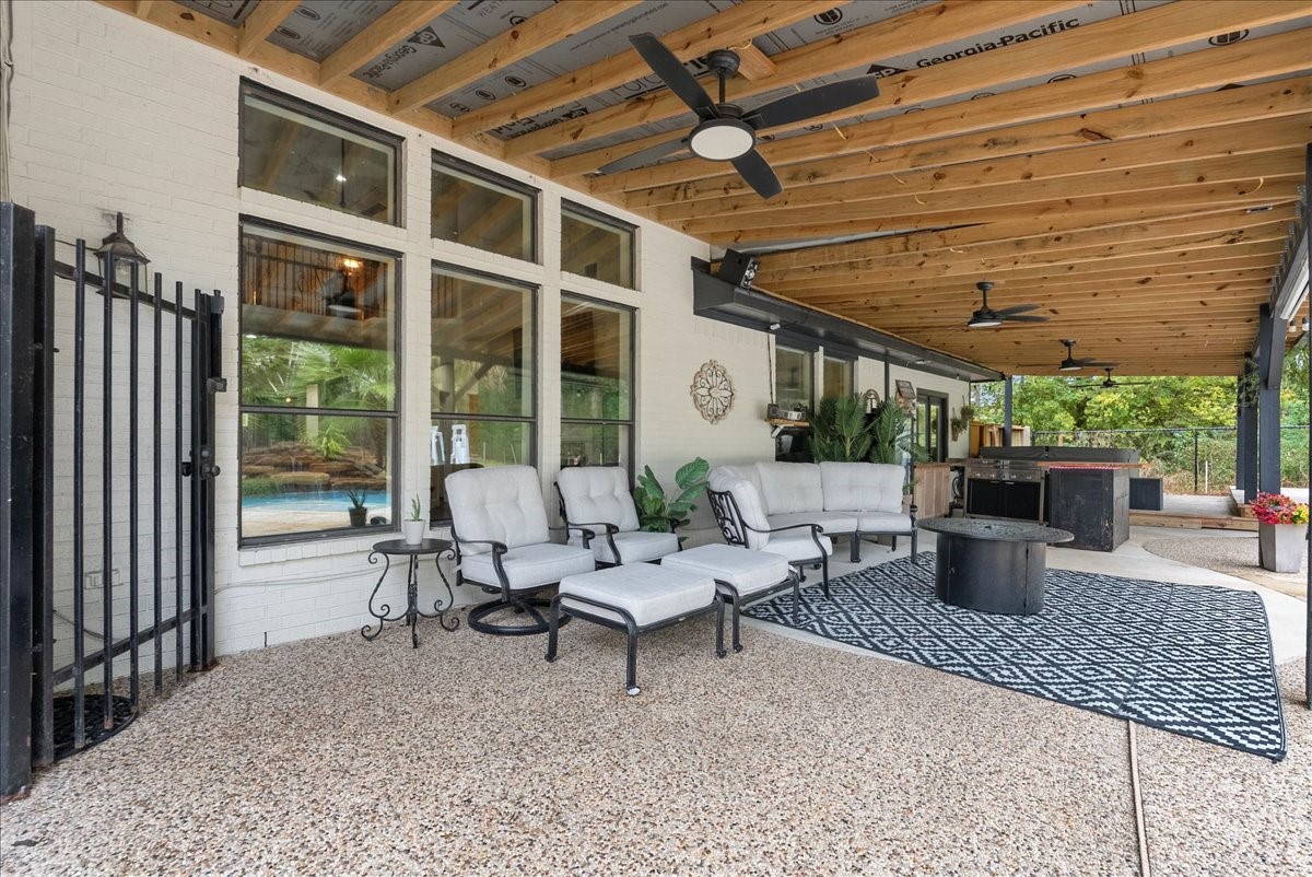 Spacious covered patio with stylish seating, ceiling fans, and a cozy fire pit, perfect for outdoor entertaining and relaxation.