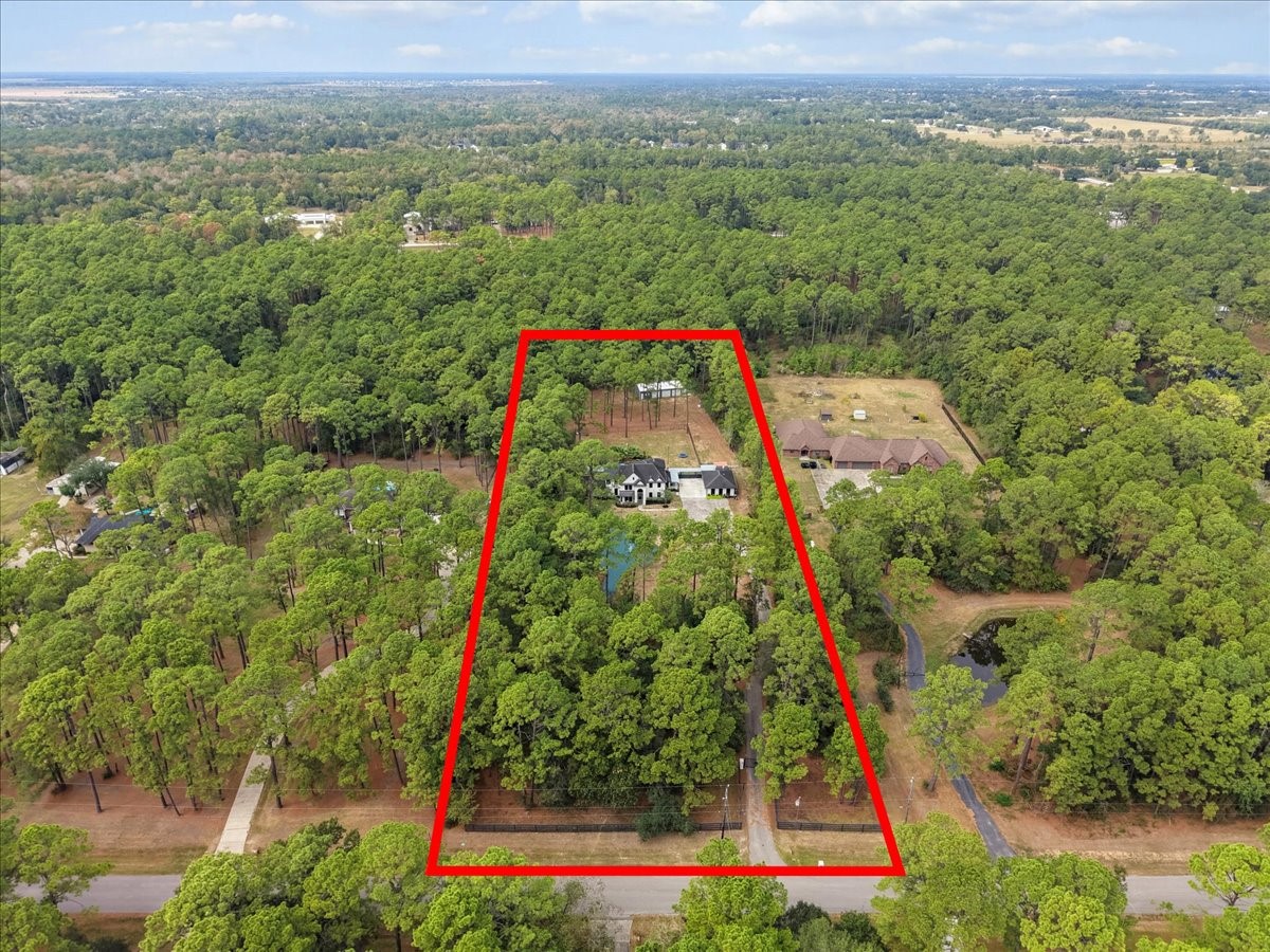 Expansive wooded five acre property offering privacy and natural beauty, featuring a spacious home nestled among the trees, perfect for serene living.