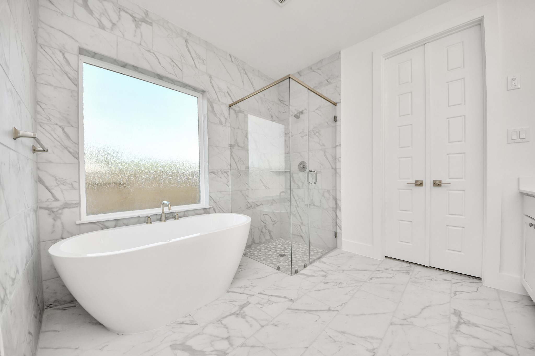 Indulge in a spa-like retreat within the confines of this primary bathroom. Delight in a spacious walk-in shower enveloped in stylish tile surround, unwind in a separate garden tub adorned with custom detailing.