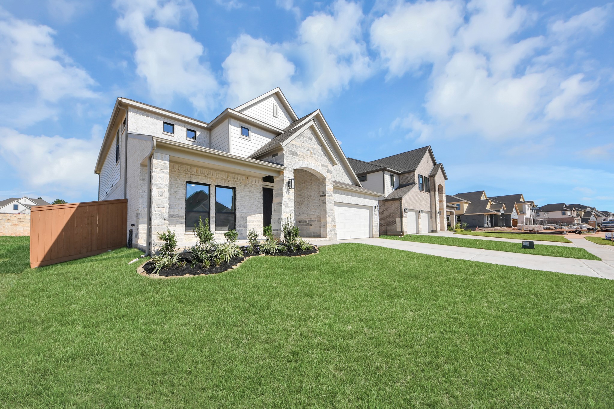 The residence features a practical 2-car garage complemented by a generous driveway, ensuring abundant space for parking needs.