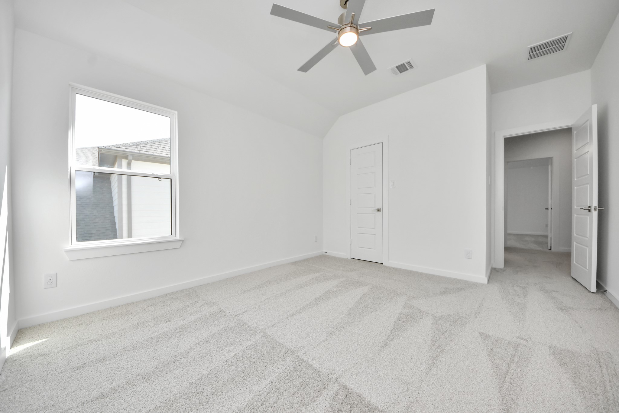Secondary bedroom features plush carpeting, large windows that let in plenty of natural light, bright paint, and spacious closets.