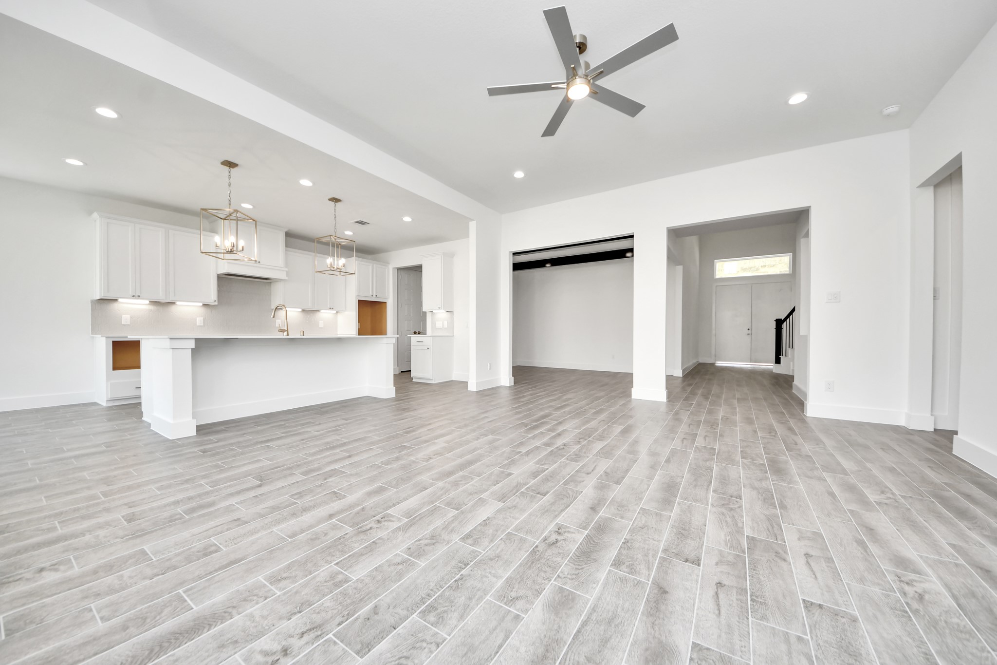 Gather the family and guests together in your lovely living room! Featuring soaring high ceilings, recessed lighting, ceiling fan, custom paint, gorgeous floors, and large windows that provide plenty of natural lighting throughout the day.