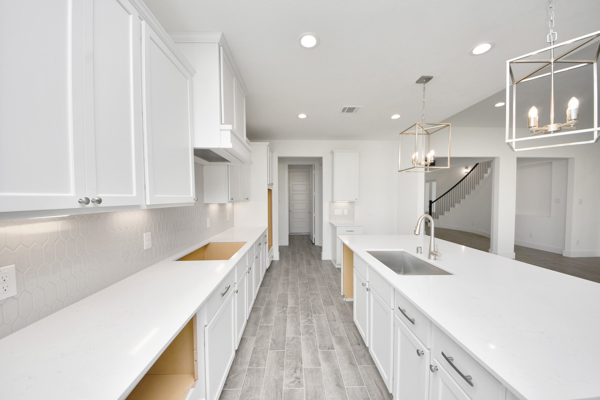 This generously spacious kitchen is a dream realized! With a massive granite island, high ceilings, soft close cabinets, granite countertops, stainless steel appliances, a sleek tile backsplash, recessed lighting, and an extended counter area, it offers both style and practicality. All this opens up to the expansive family room, creating a perfect hub for gatherings.