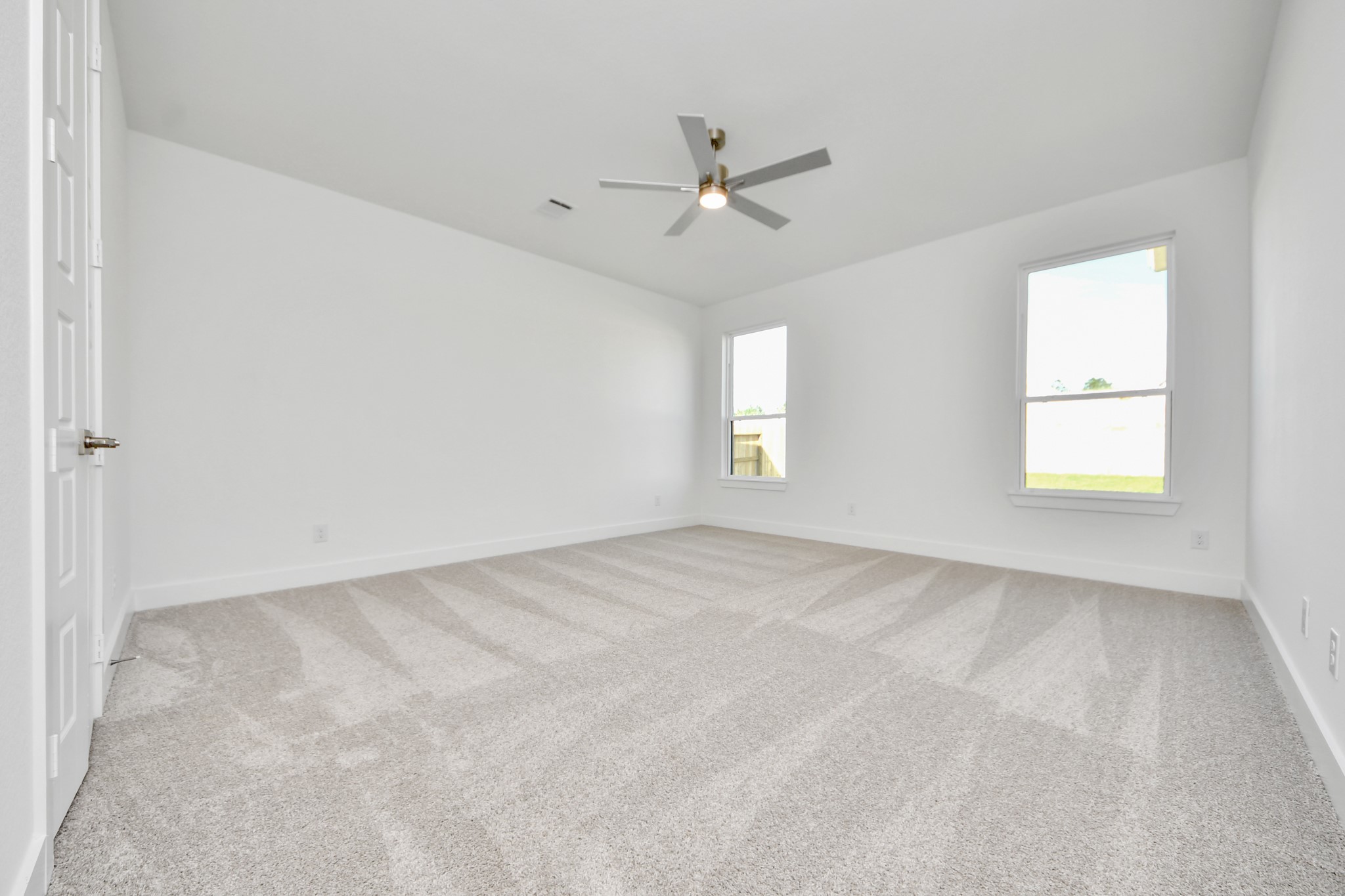 Retreat to the luxurious primary suite, your perfect escape for unwinding after a long day. Located on the first floor, this spacious room features plush carpeting, calming paint tones, high ceilings, and large windows with privacy blinds.