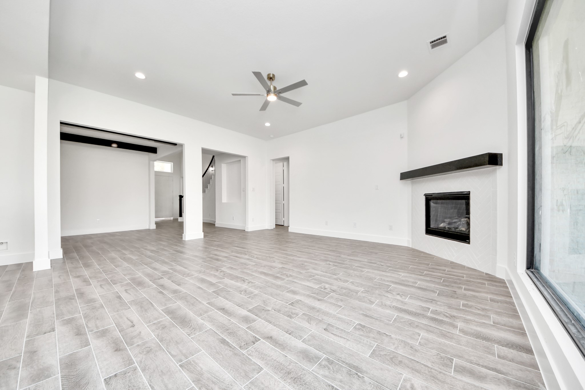 Relax and unwind in this inviting family room, illuminated by abundant natural light streaming in through tall windows, complemented by high ceilings and stunning flooring. Stay comfortable year-round with the gentle breeze from the ceiling fan, creating the perfect atmosphere for family gatherings.