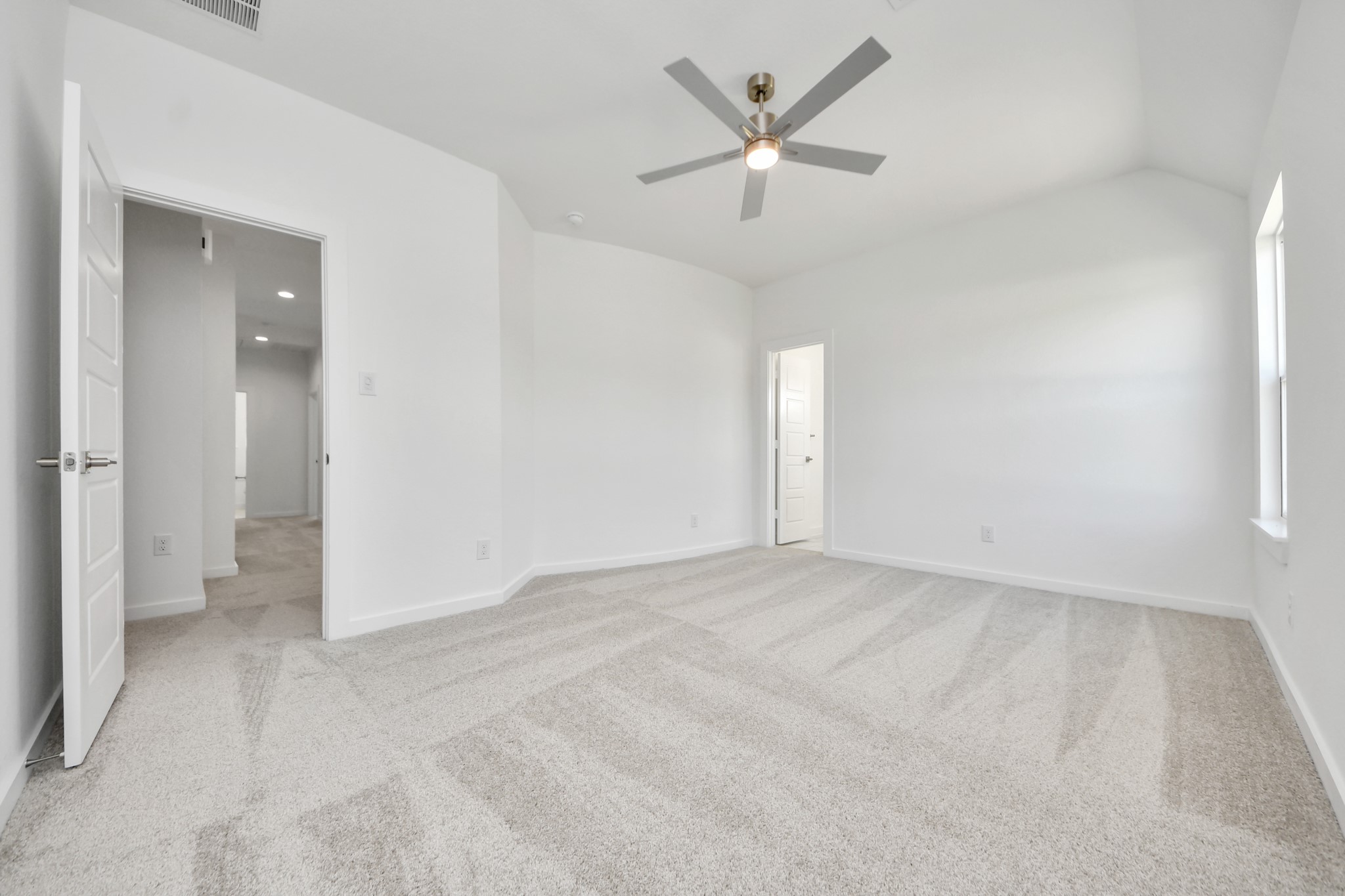 Secondary bedroom features plush carpeting, large windows that let in plenty of natural light, bright paint, and spacious closets.