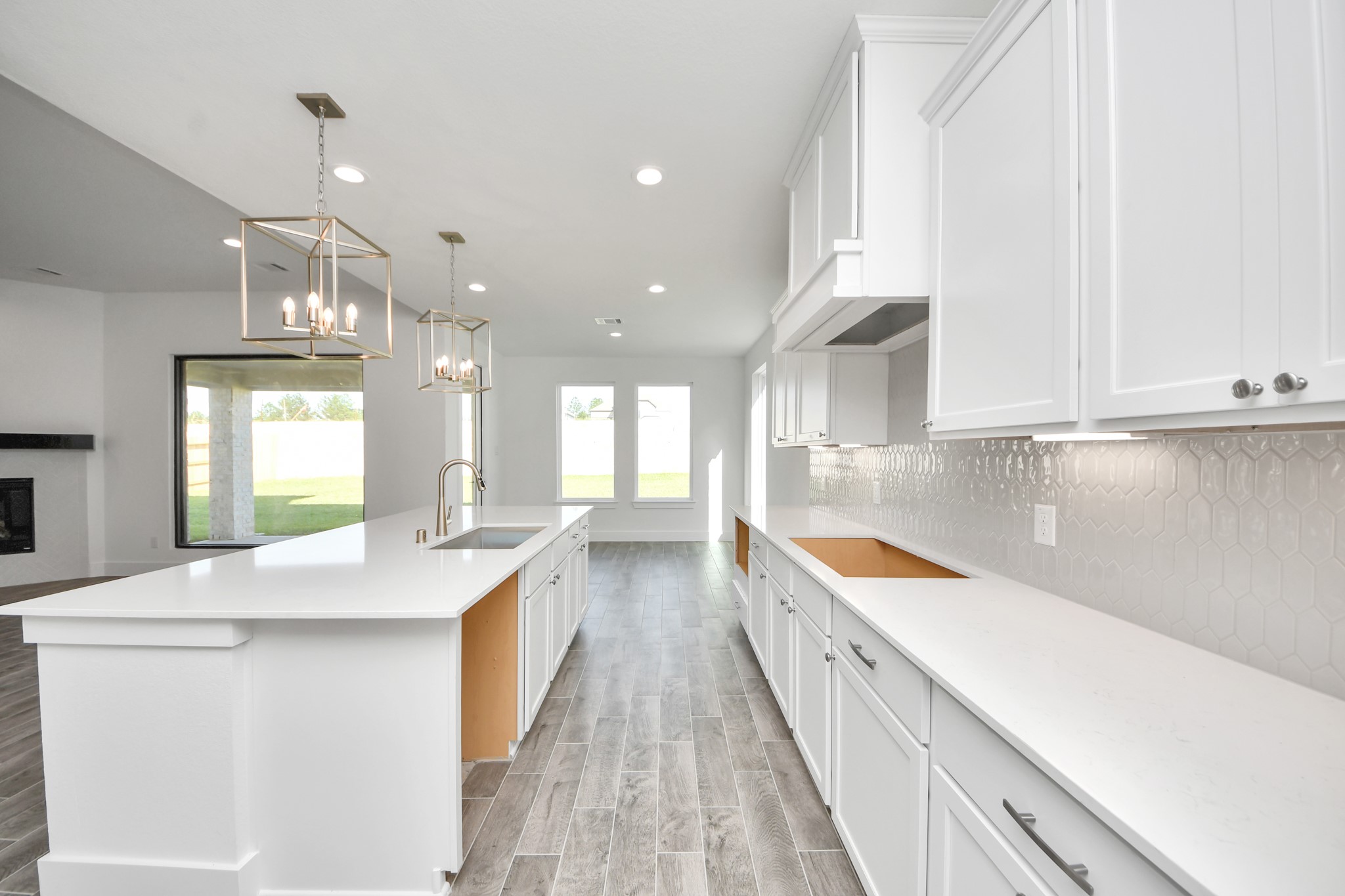 This kitchen is truly a chef's dream! This haven Boasts high ceilings, recessed & pendant lighting, stained wood cabinets, granite countertops, stainless steel appliances, a modern tile backsplash.  All of this overlooks your expansive family room, creating a perfect space for culinary delights and family gatherings.