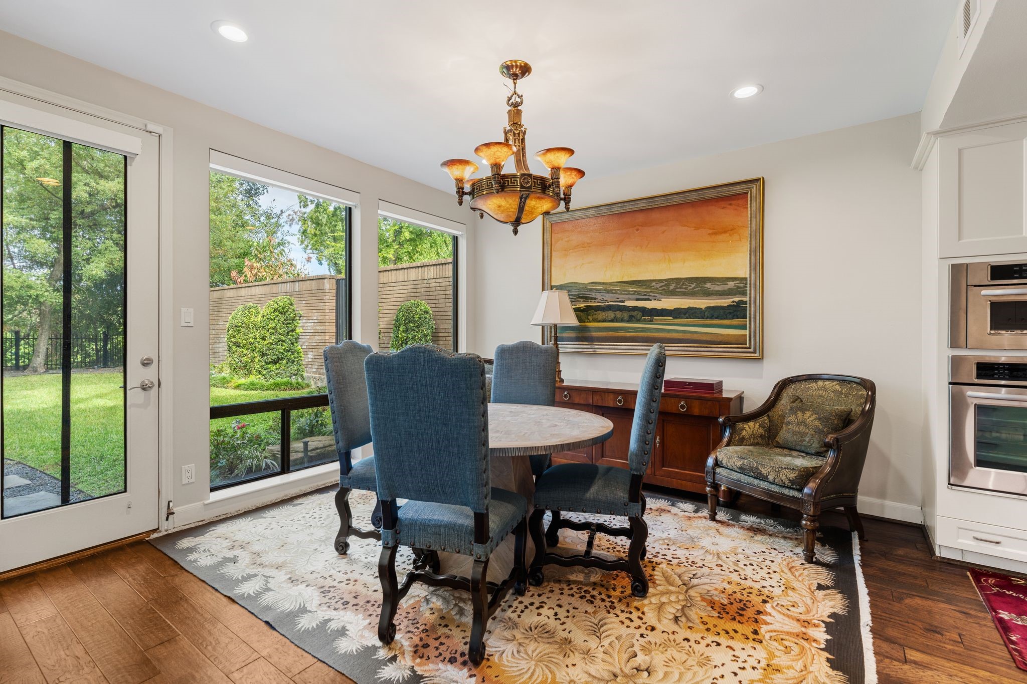 Enjoy morning coffee in the breakfast area, where large windows frame views of the lawn and mature trees.
